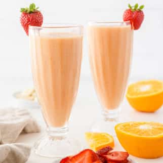 two strawberry smoothies and an orange