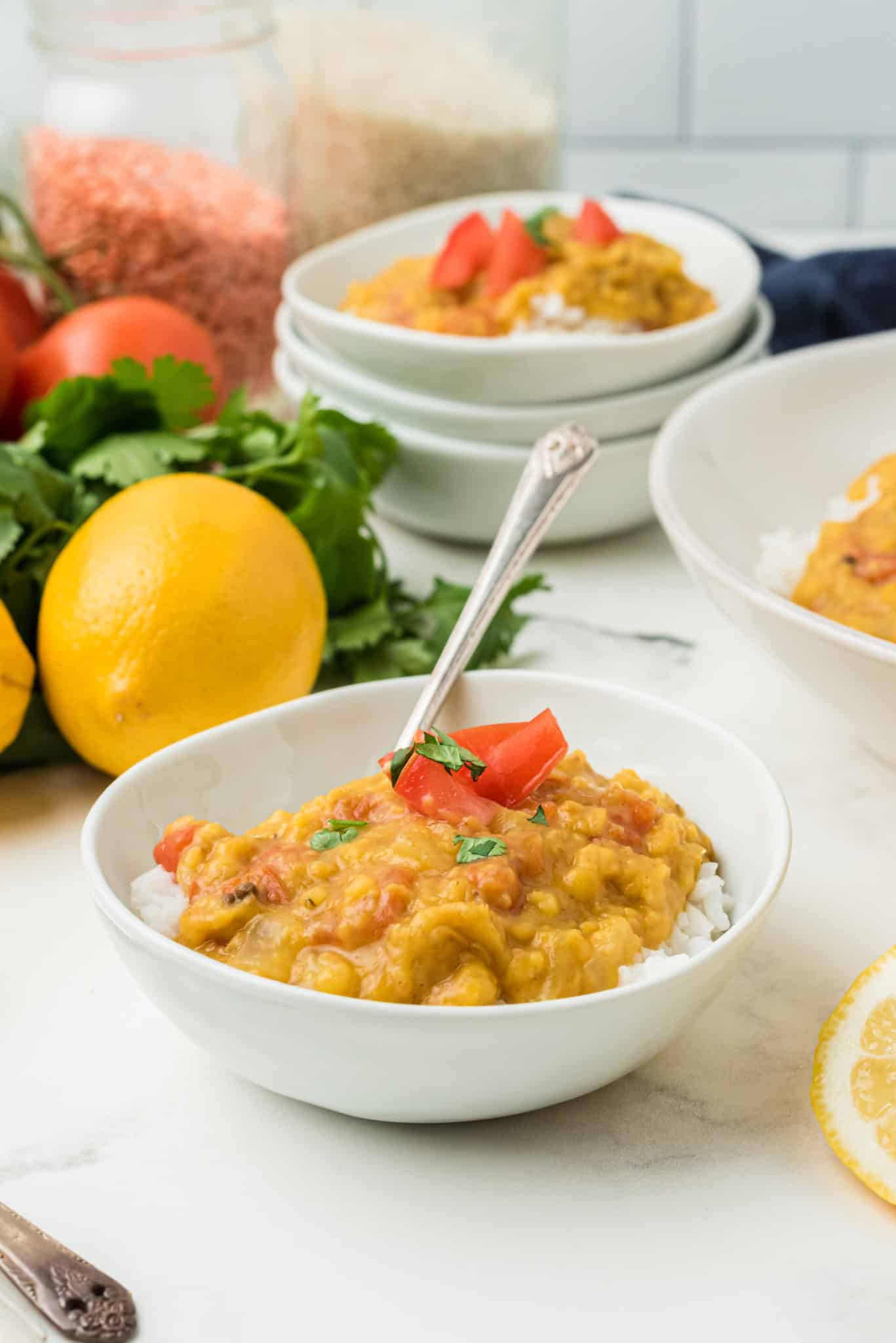 servings of instant pot red lentil dal topped with fresh tomatoes.