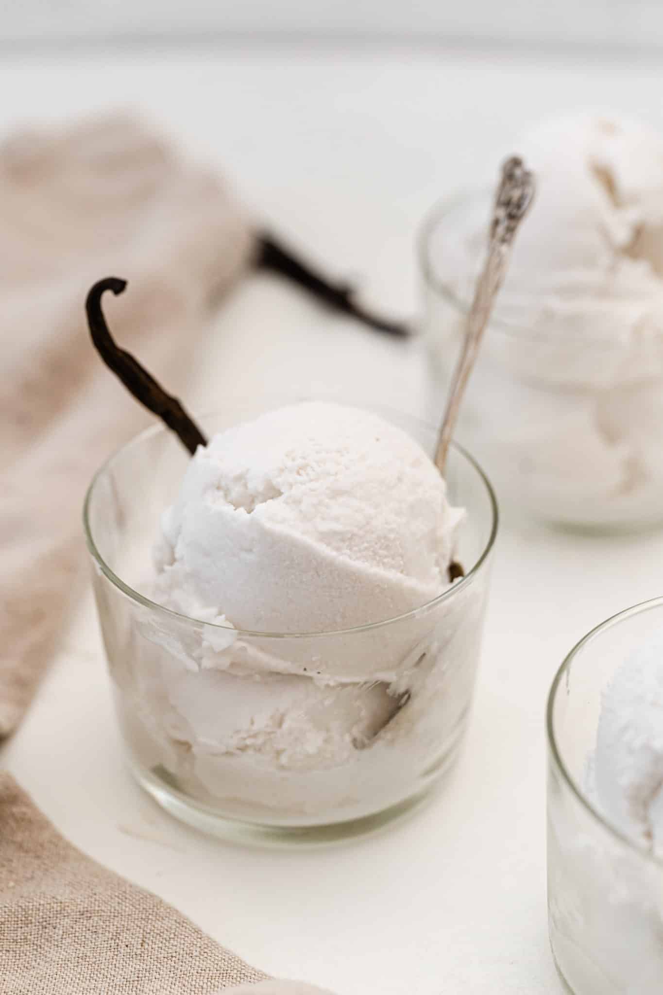 Homemade blender vanilla ice cream with vanilla bean in a glass cup.