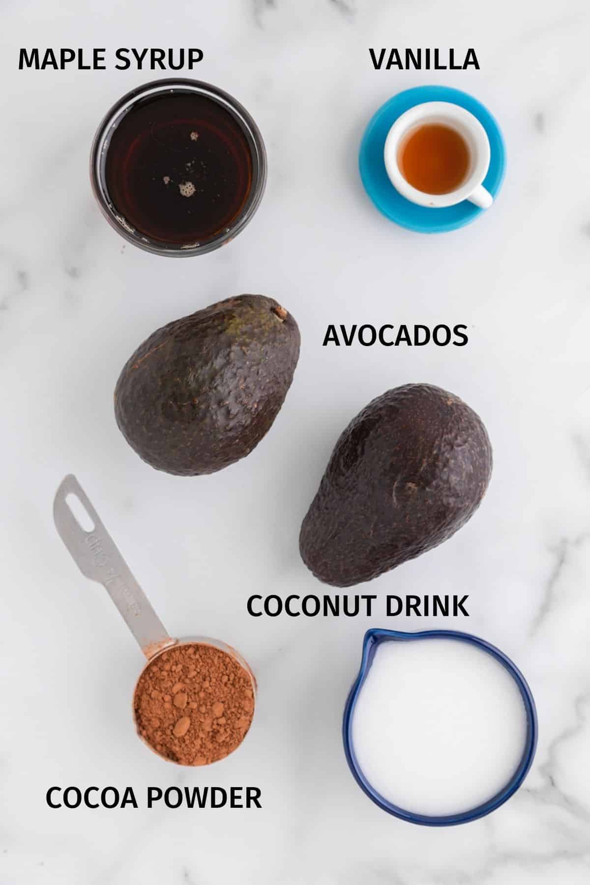 Ingredients for avocado vegan ice cream set on a white surface.