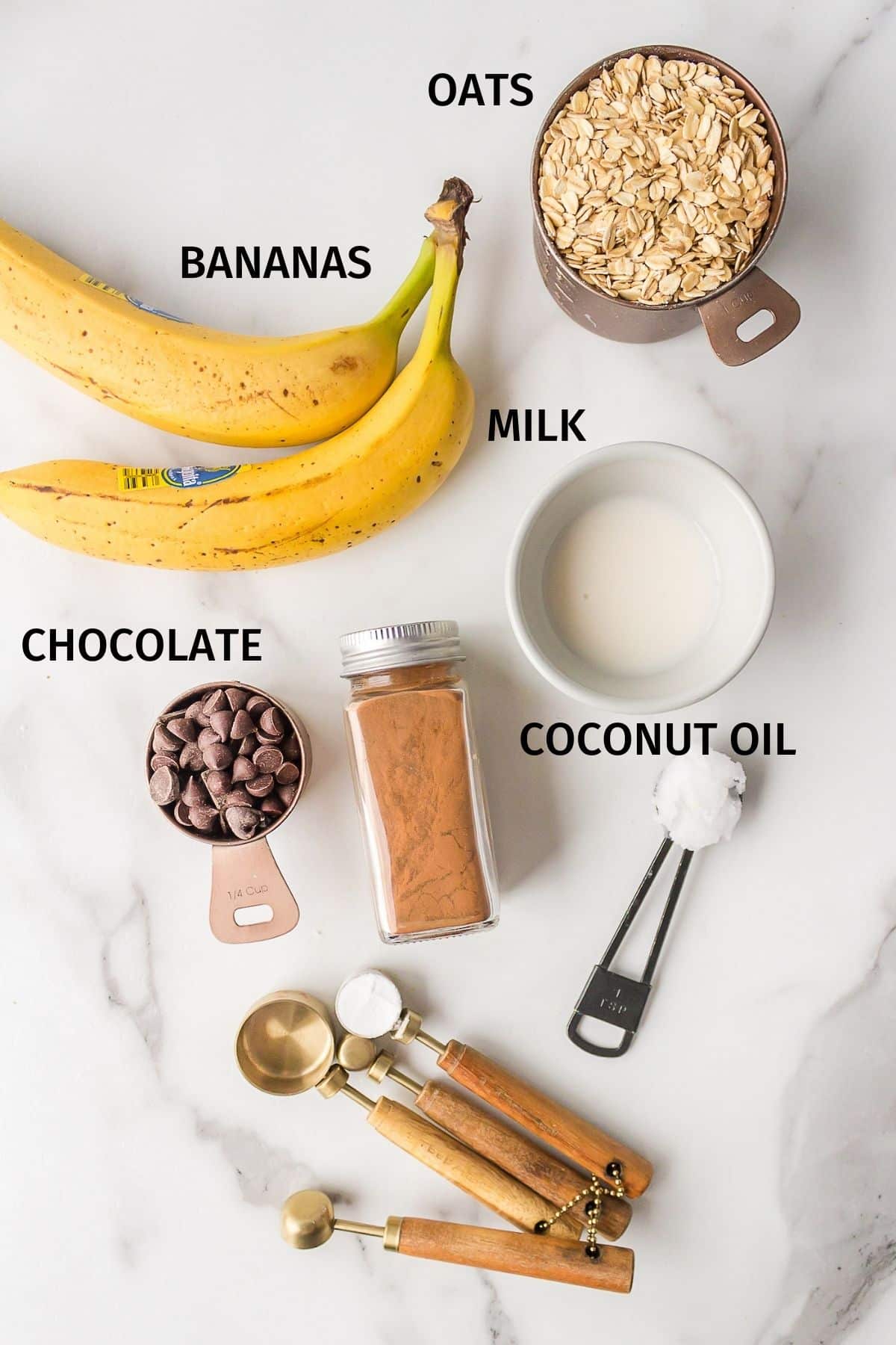 Labeled ingredients needed for banana oatmeal cookies on a white surface.