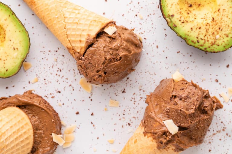 Close up of three sugar cones each with a scoop of chocolate avocado ice cream.
