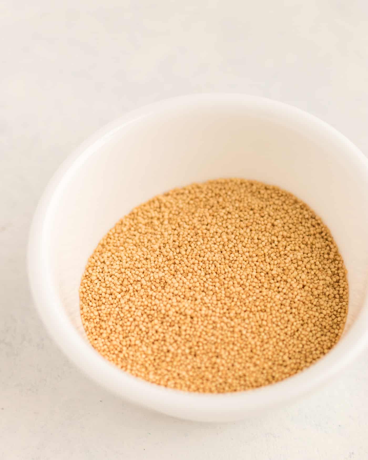 uncooked amaranth grain in a small bowl.