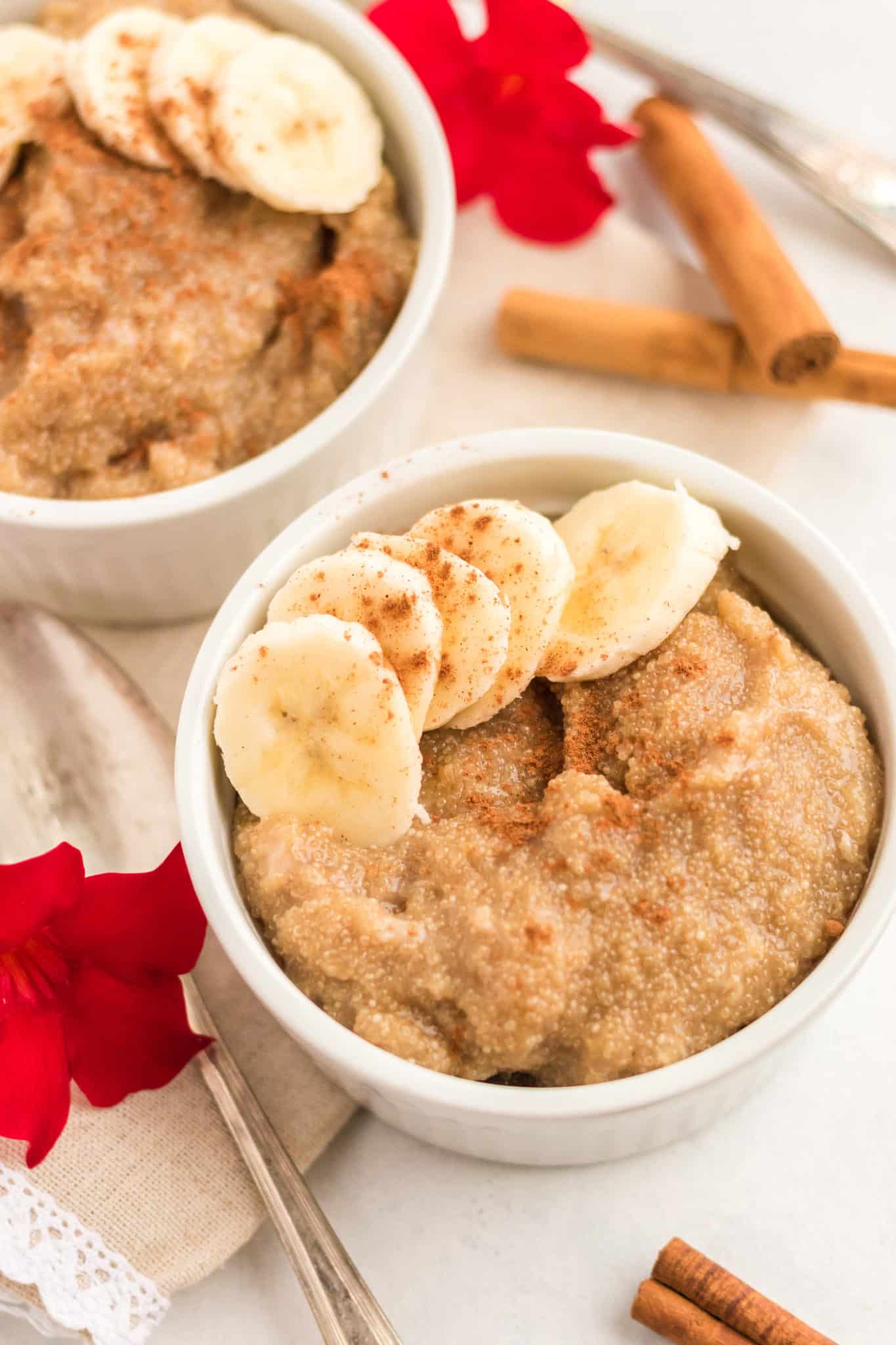 two bowls of amaranth porridge topped with sliced bananas.