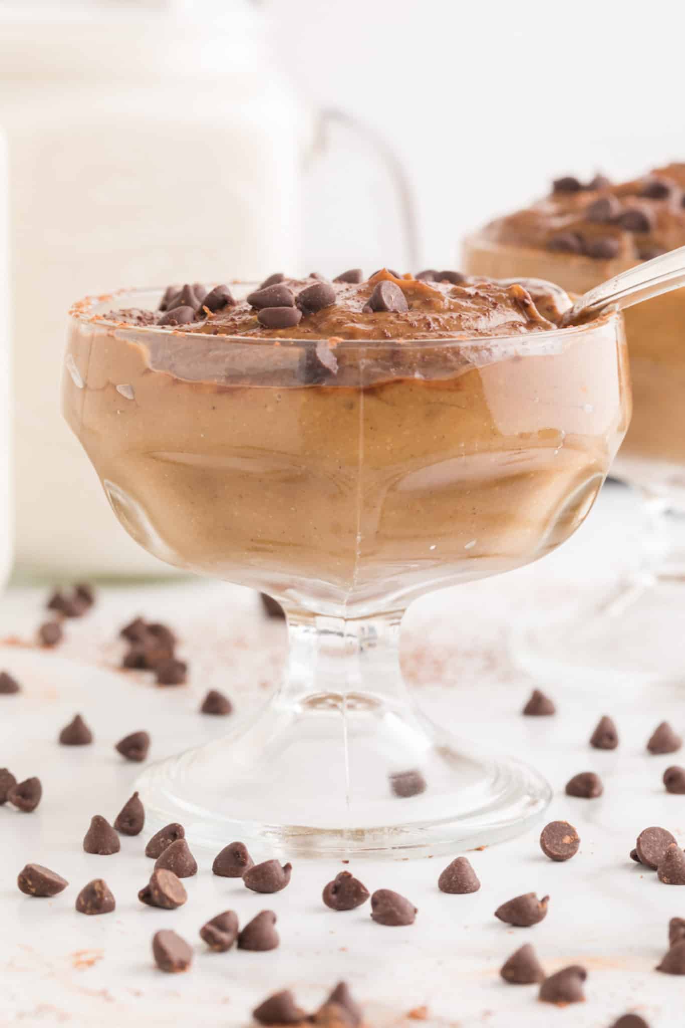 Large parfait cup of chocolate avocado pudding topped with chocolate chips.