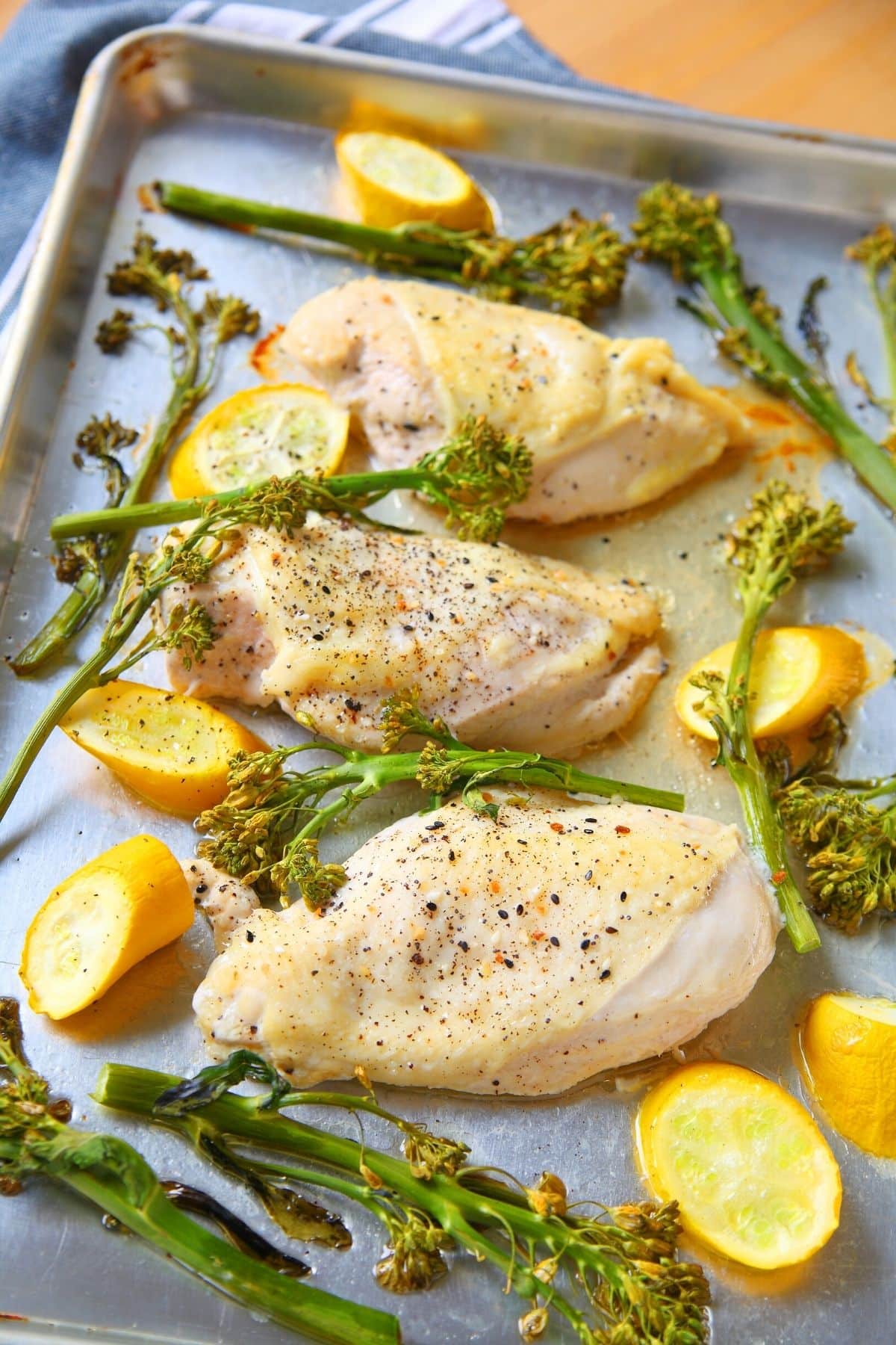 baked lemon chicken with broccoli on sheet pan.