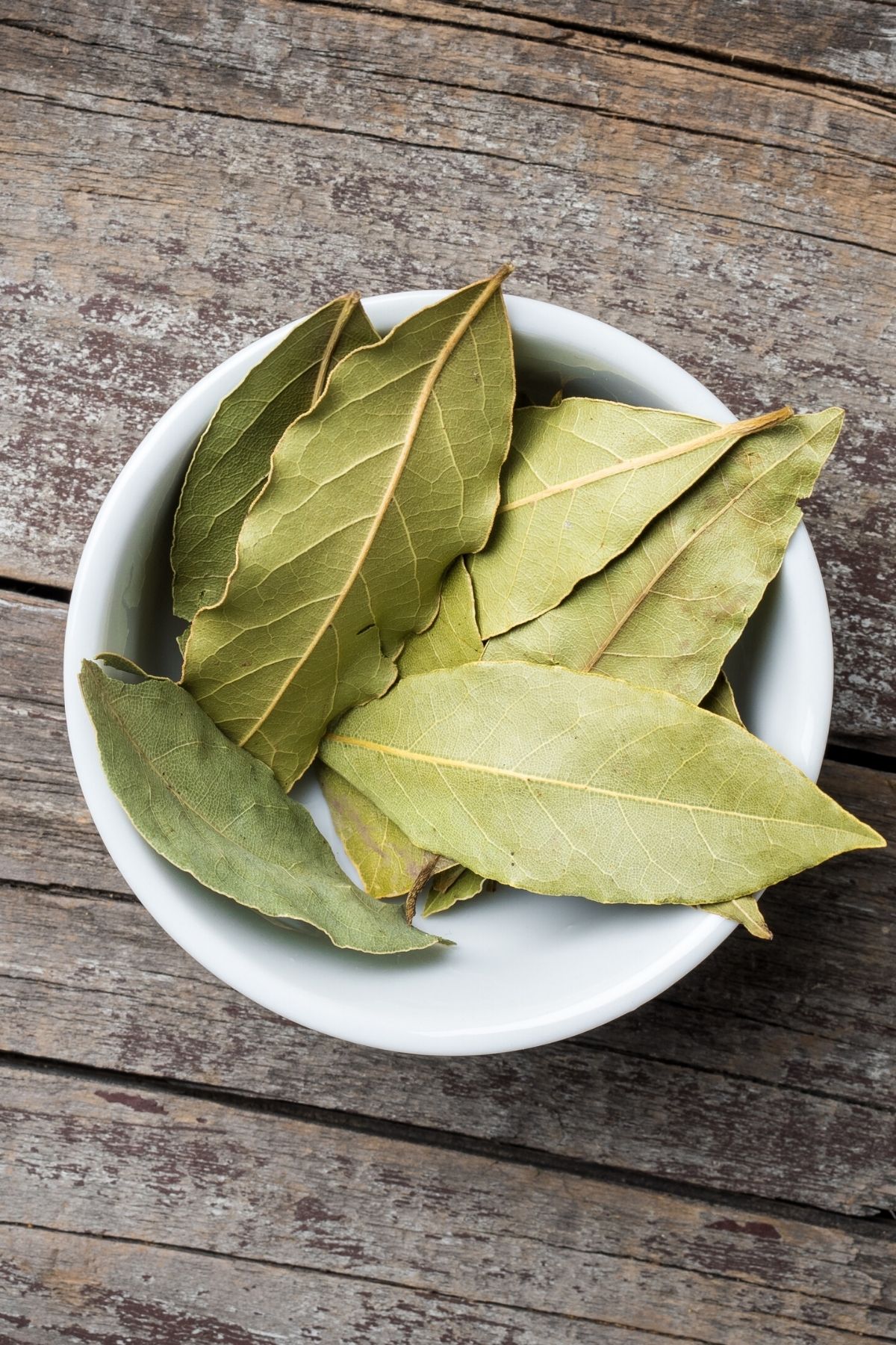 Close up of dried bay leaves in a bowl.