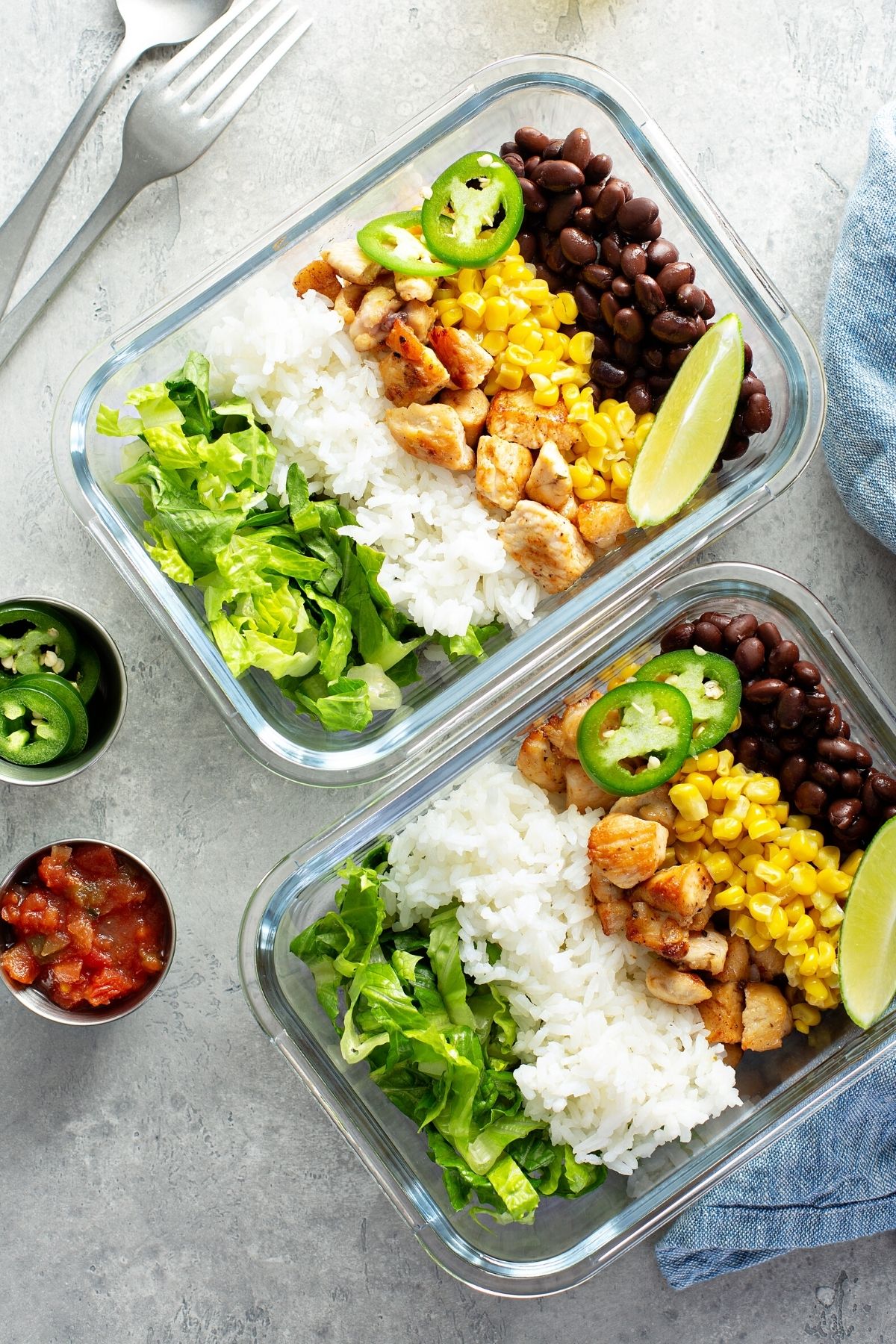 chicken and rice and black bean meal prep in two glass bowls.