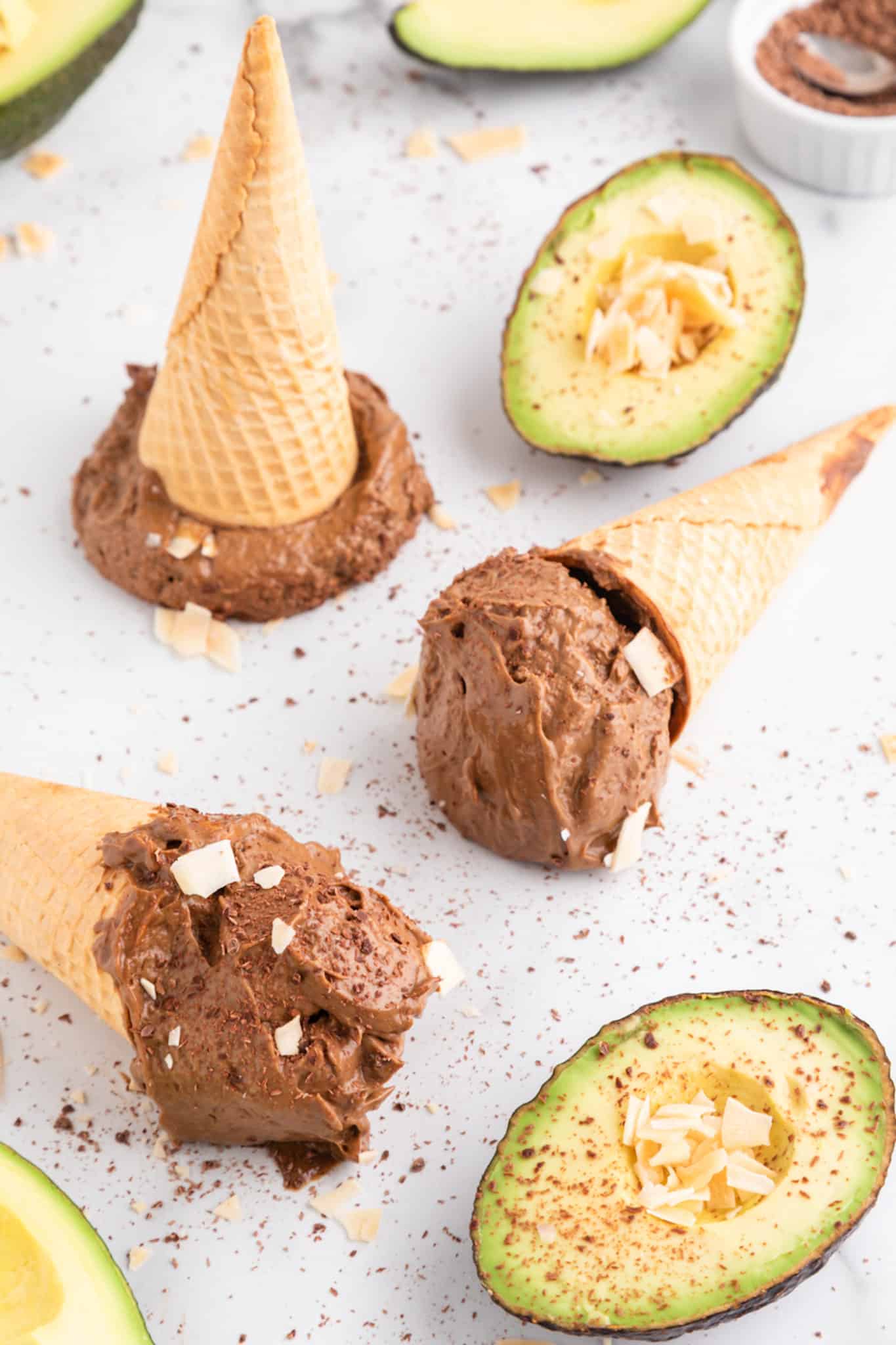 Three sugar cones on their sides filled with avocado chocolate ice cream.