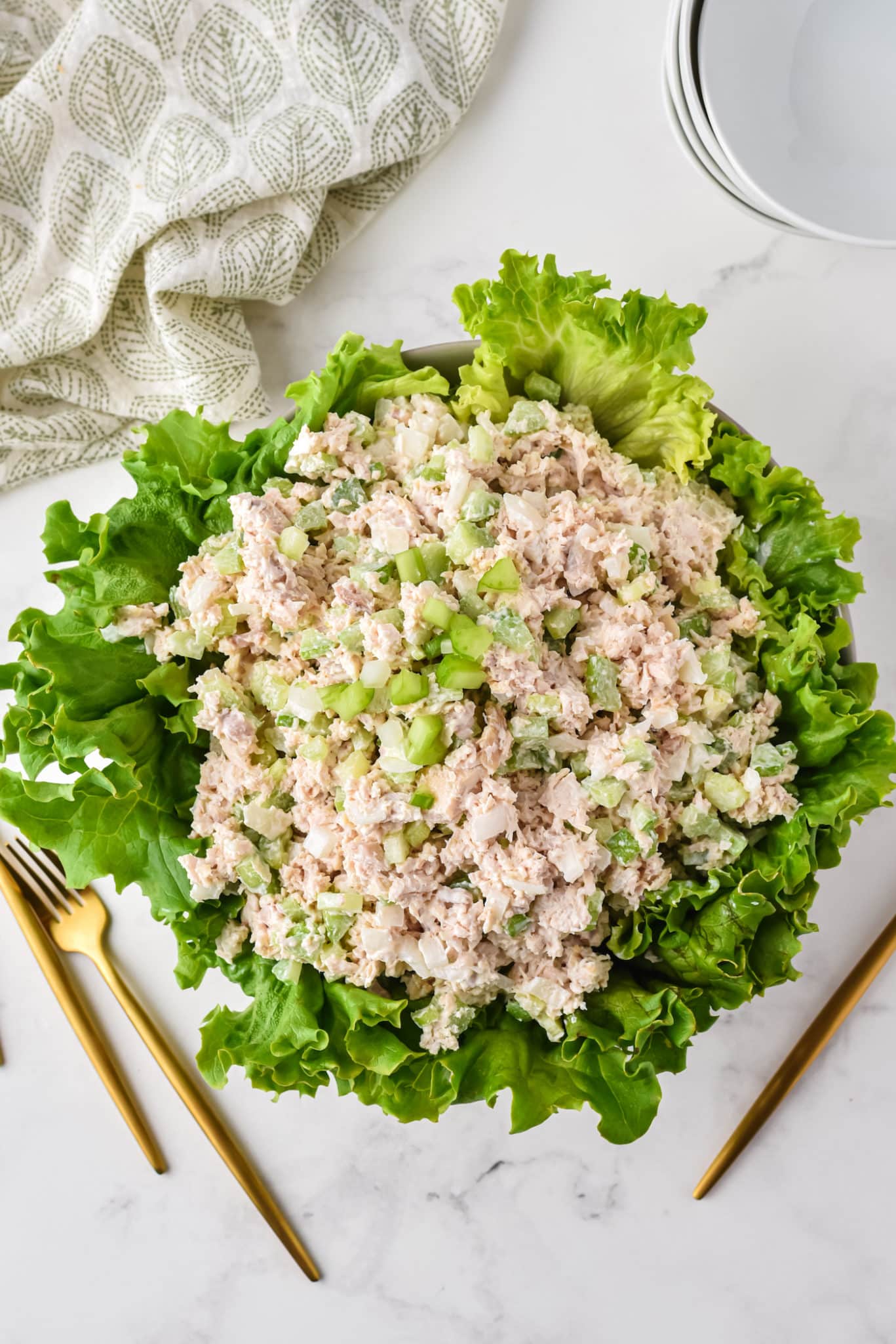 Large serving bowl of green lettuce topped with costco chicken salad.
