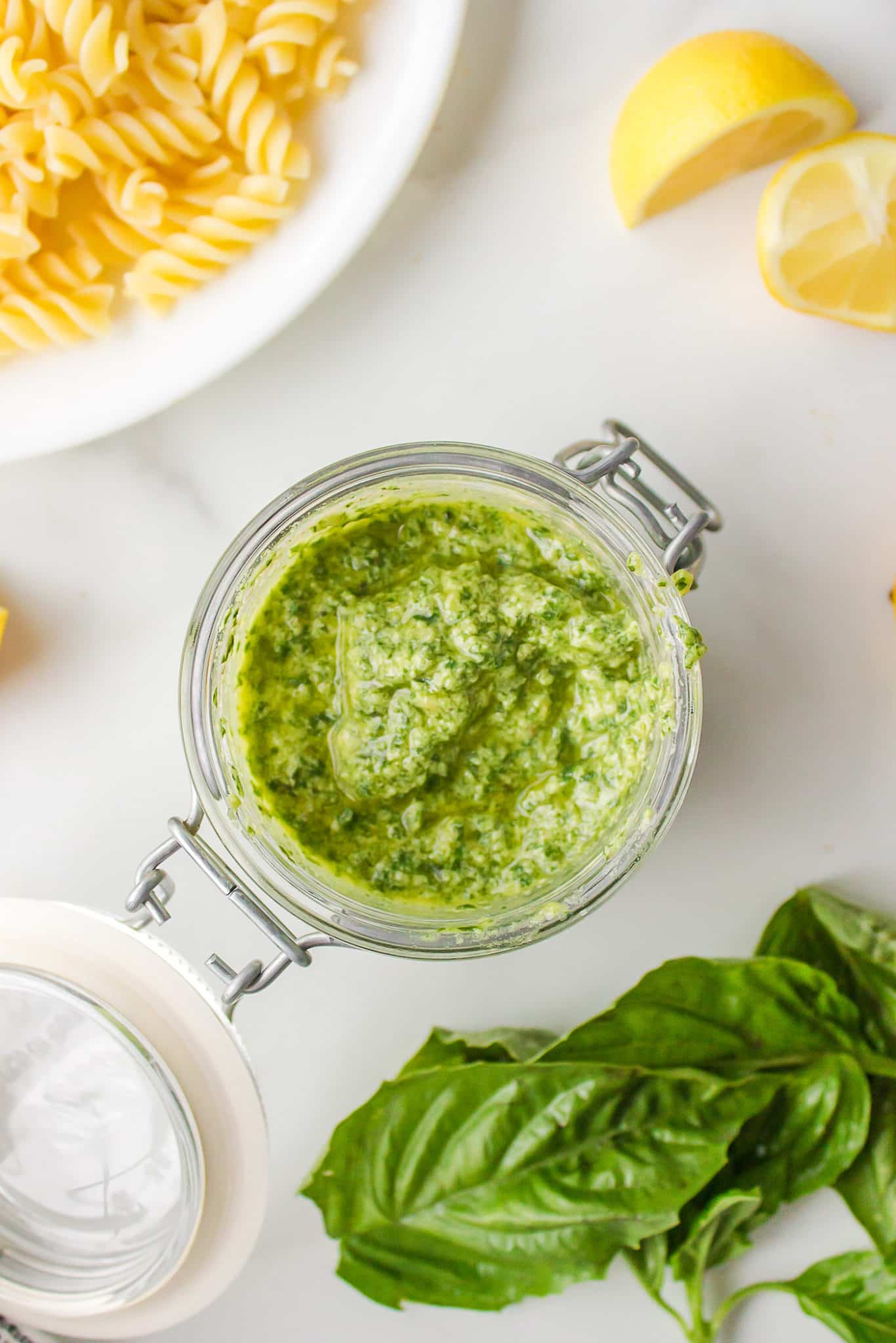 Looking inside a flip-top glass jar filled with pesto made without cheese.