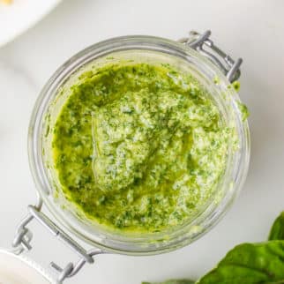 Looking inside a flip-top glass jar filled with pesto.