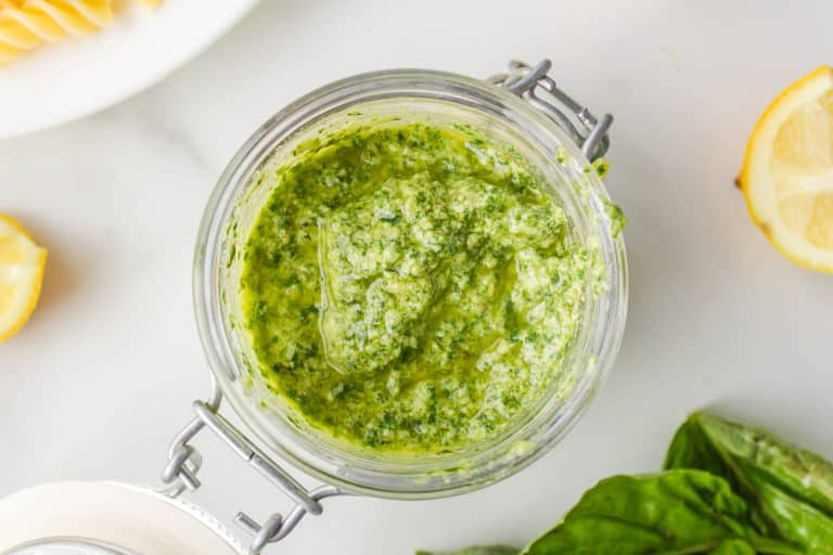 Looking inside a flip-top glass jar filled with pesto.