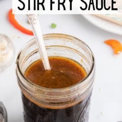 A silver spoon in a jar of homemade gluten-free stir fry sauce.