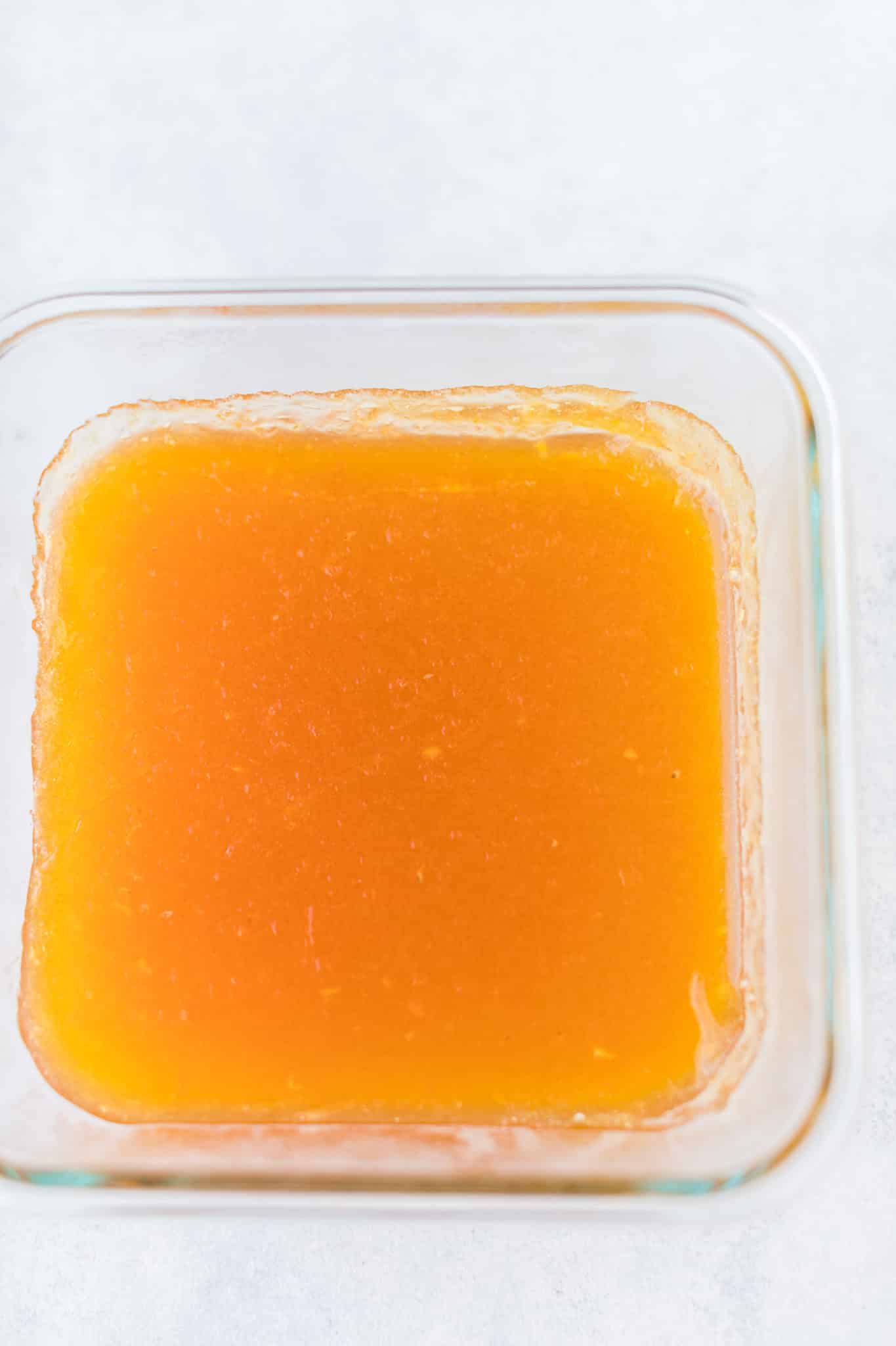 homemade orange jello in a baking dish to set.