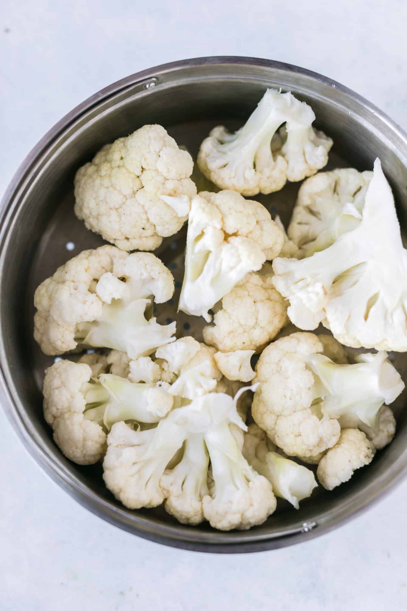 cauliflower florets in a steamer basket.