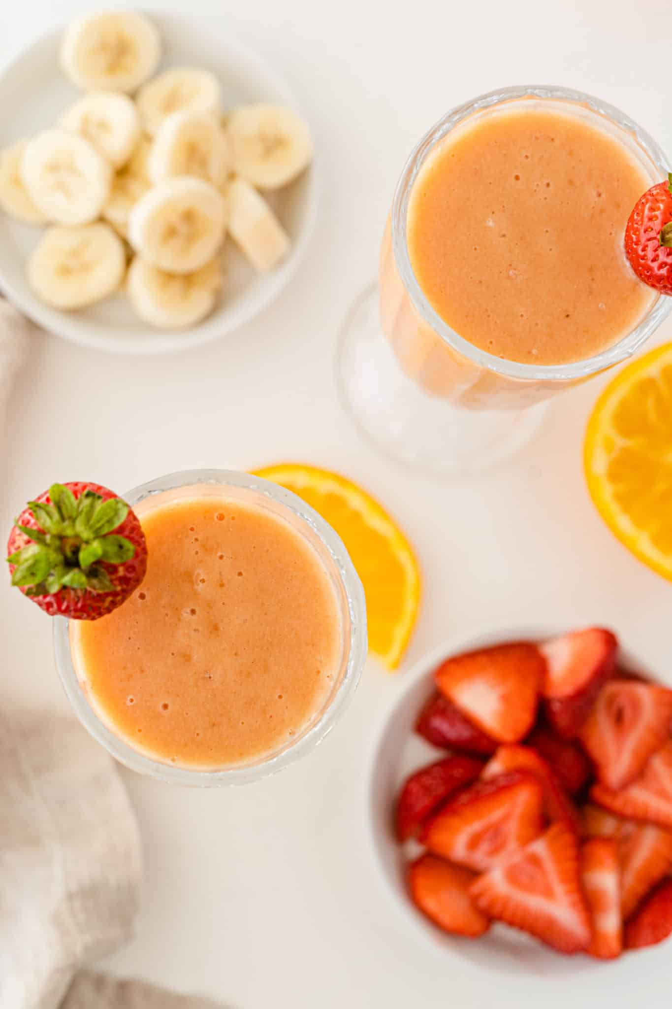 two glasses of orange strawberry smoothie.