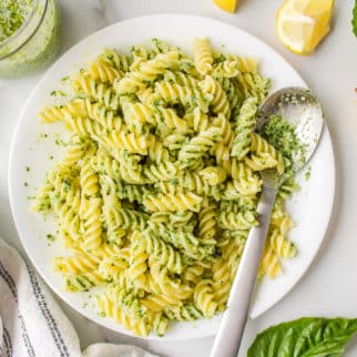 plate of vegan pesto pasta served with a spoon.