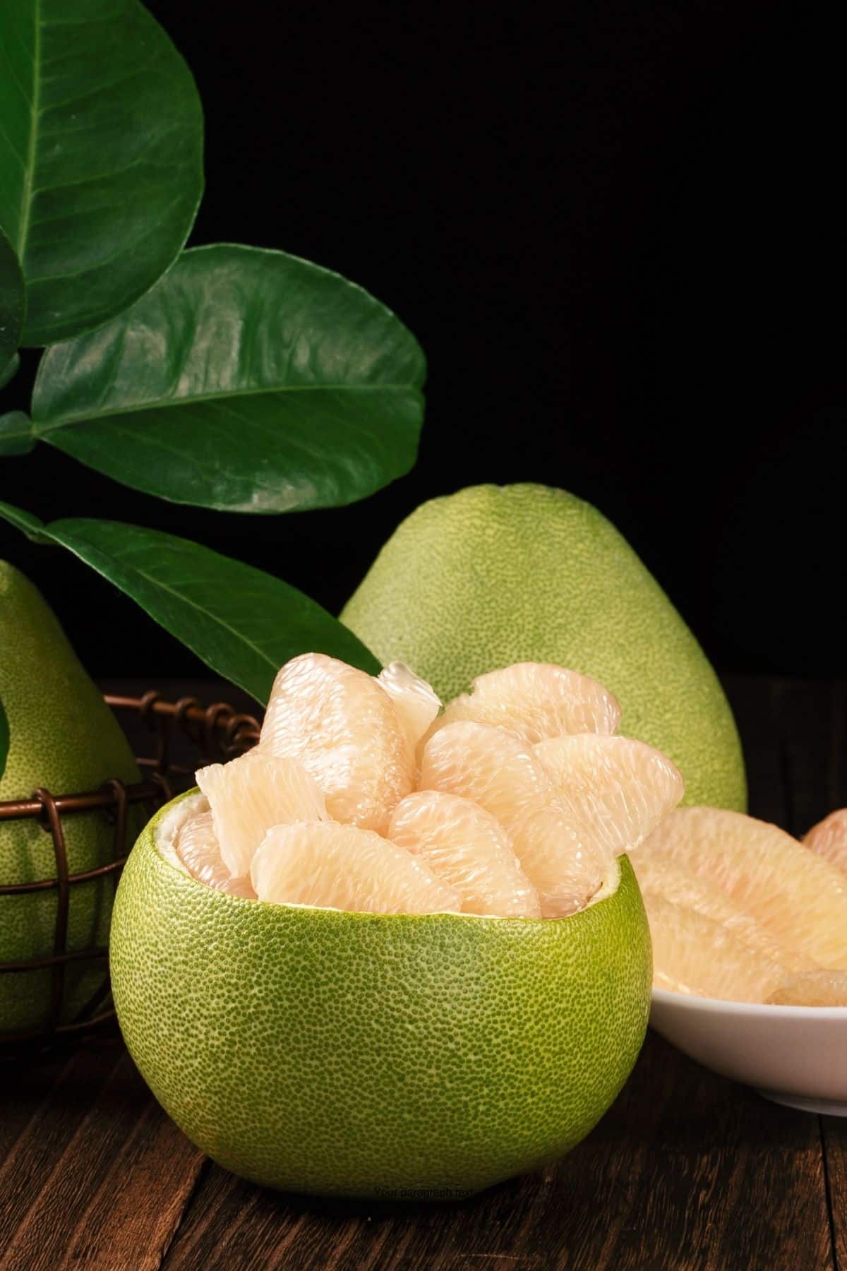 Pomelo fruit cut into wedges in the skin.