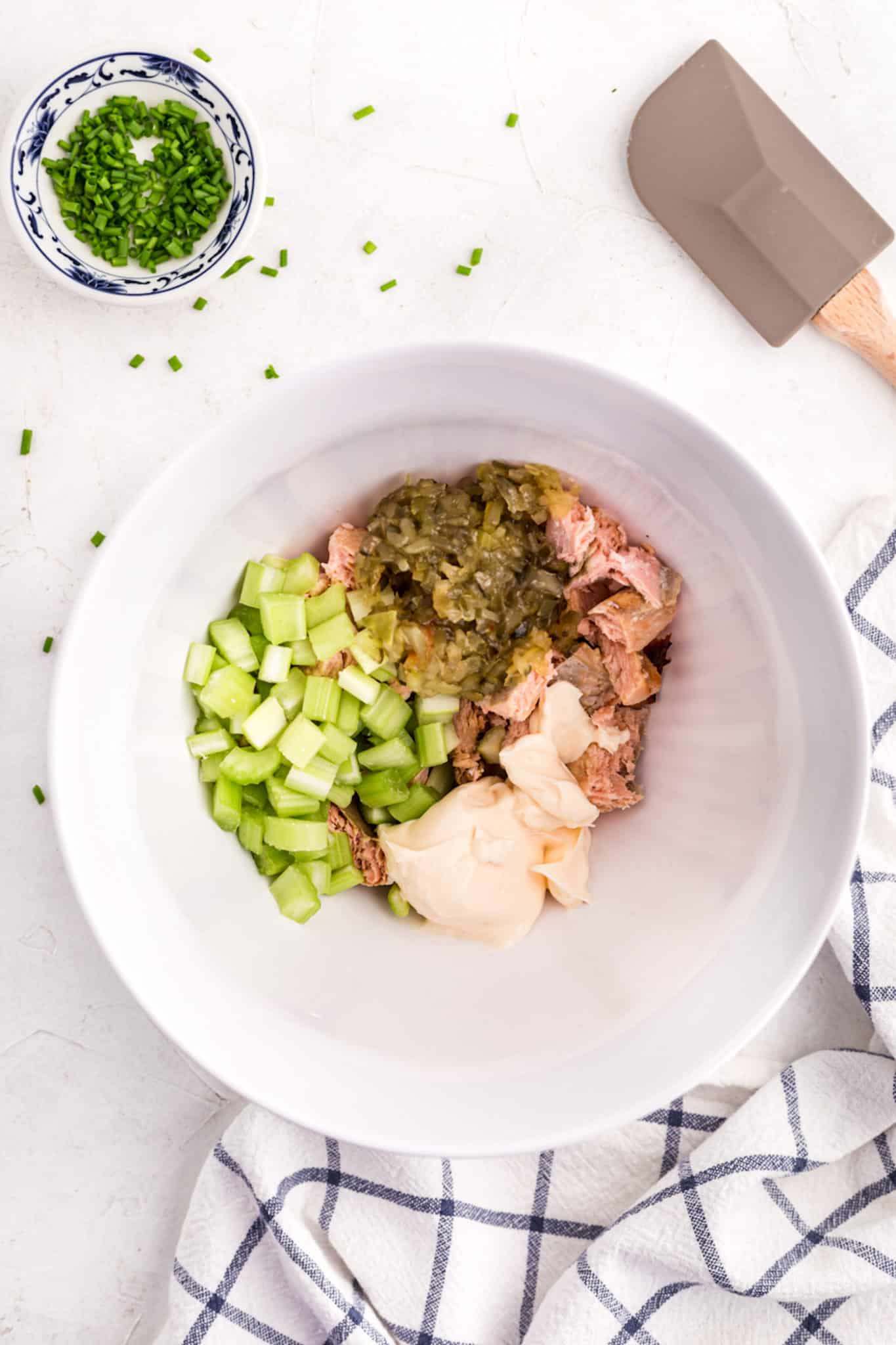 Diced salmon salad ingredients in a large white mixing bowl.