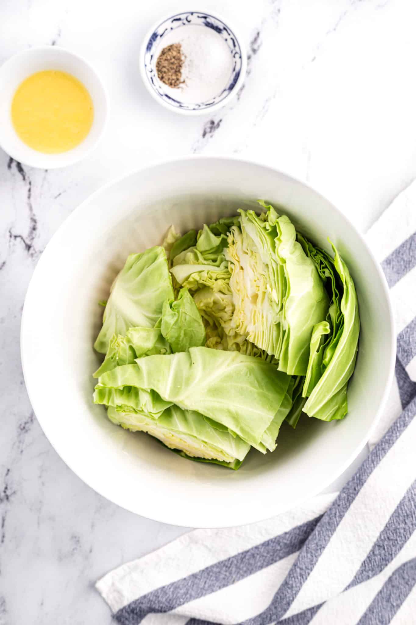 Cut cabbage in a white mixing bowl.
