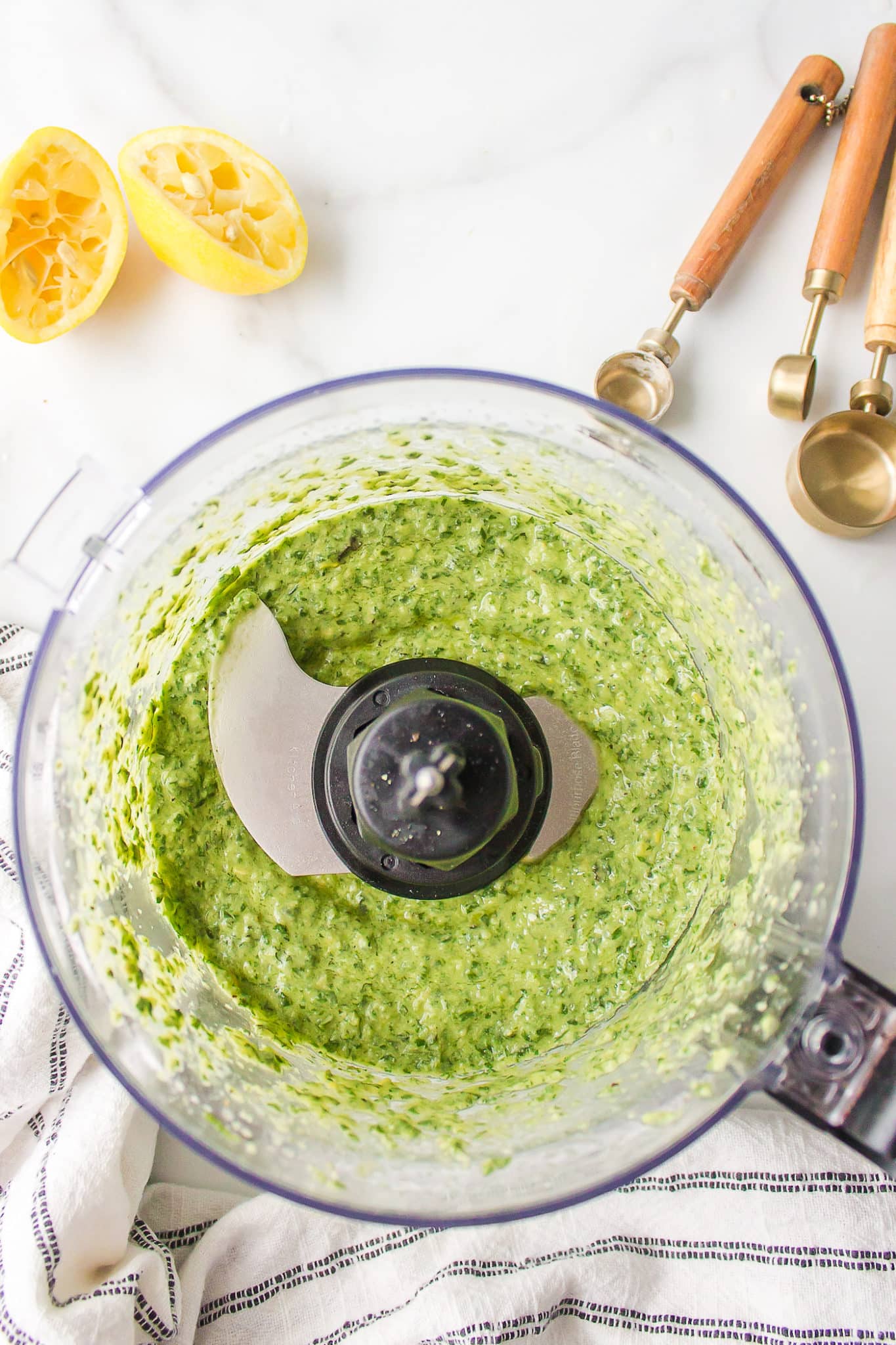 Dairy free pesto combined in the bowl of a food procesor.