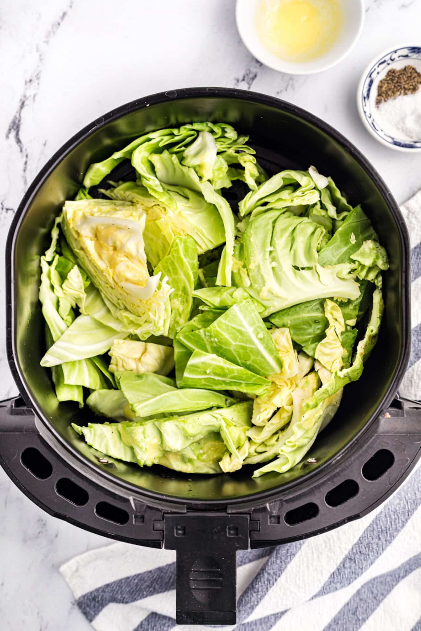 Cut cabbage in an air fryer basket.