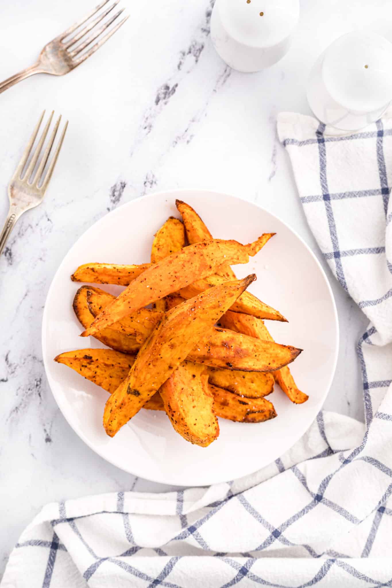 baked sweet potato wedges served in a white bowl. 