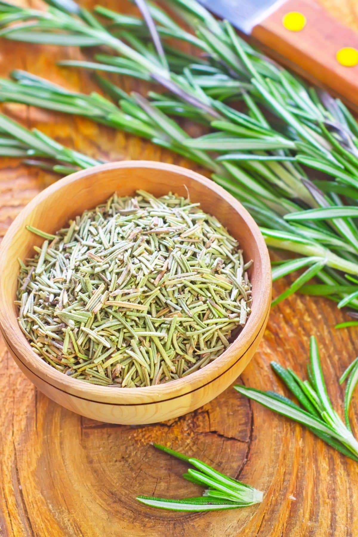 A bowl of dried rosemary next to fresh rosemary.