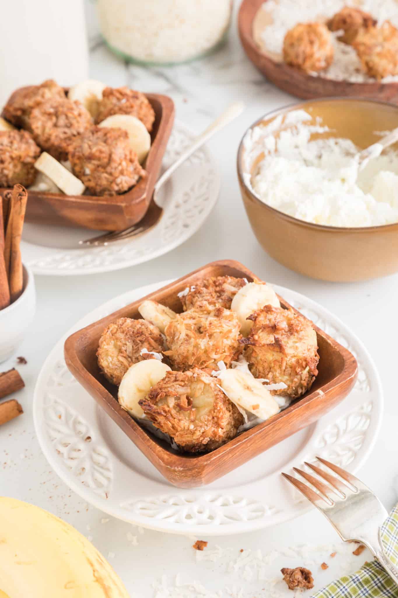 banana fritters served in a bowl with fresh whipped cream.
