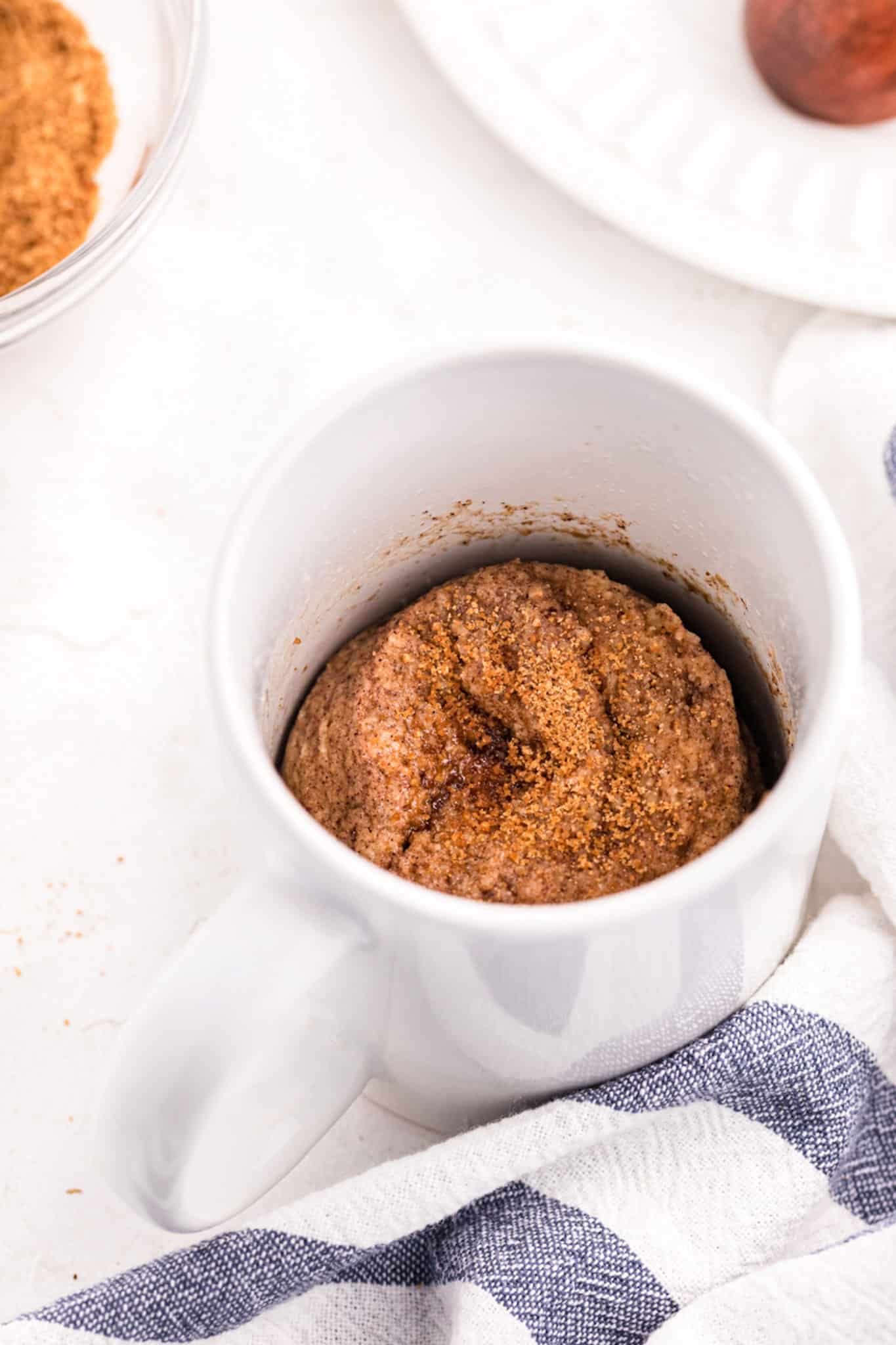 A microwaved snickerdoodle mug cake in a small white mug.
