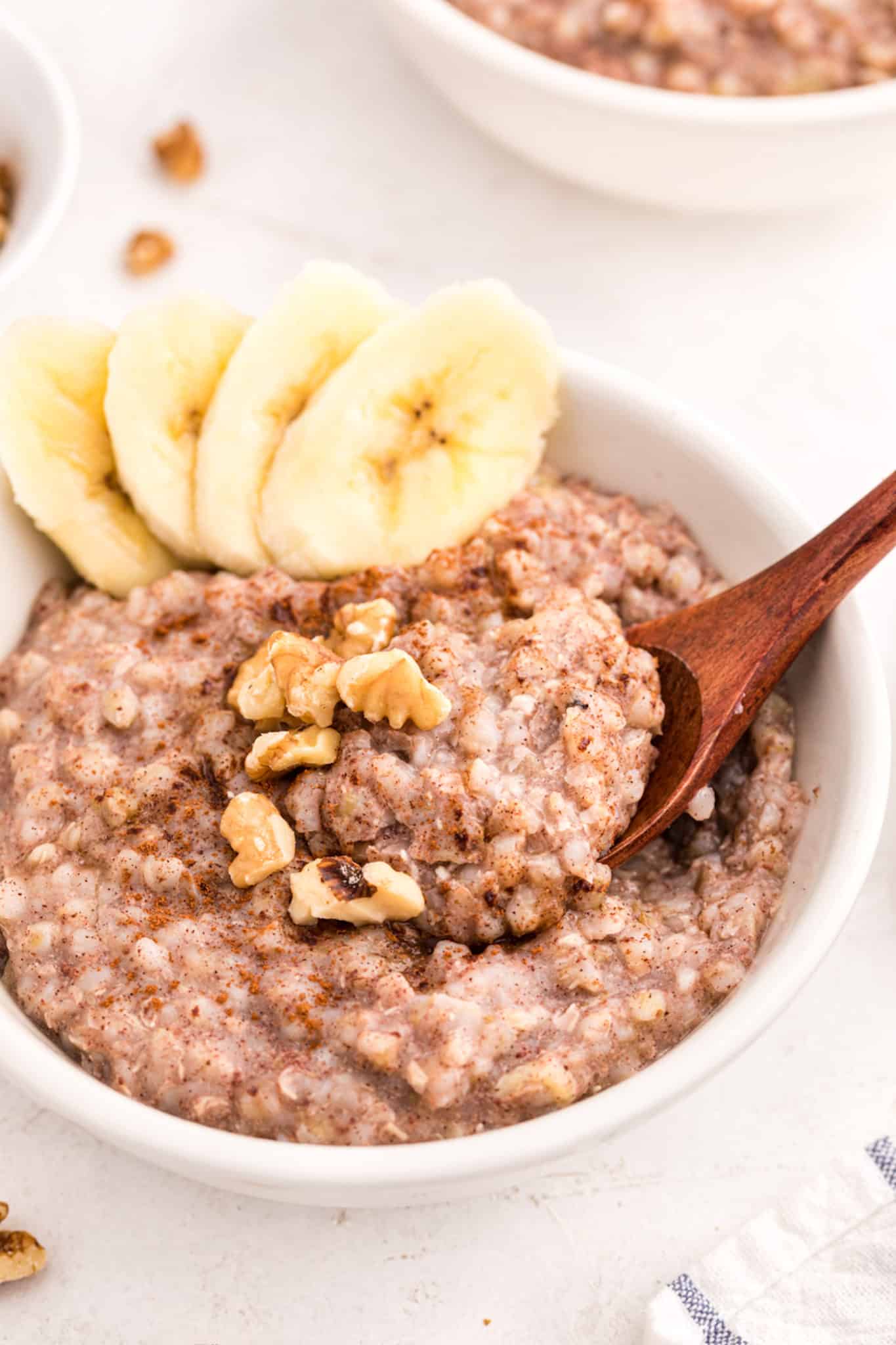 buckwheat porridge in a bowl with sliced bananas and walnuts.