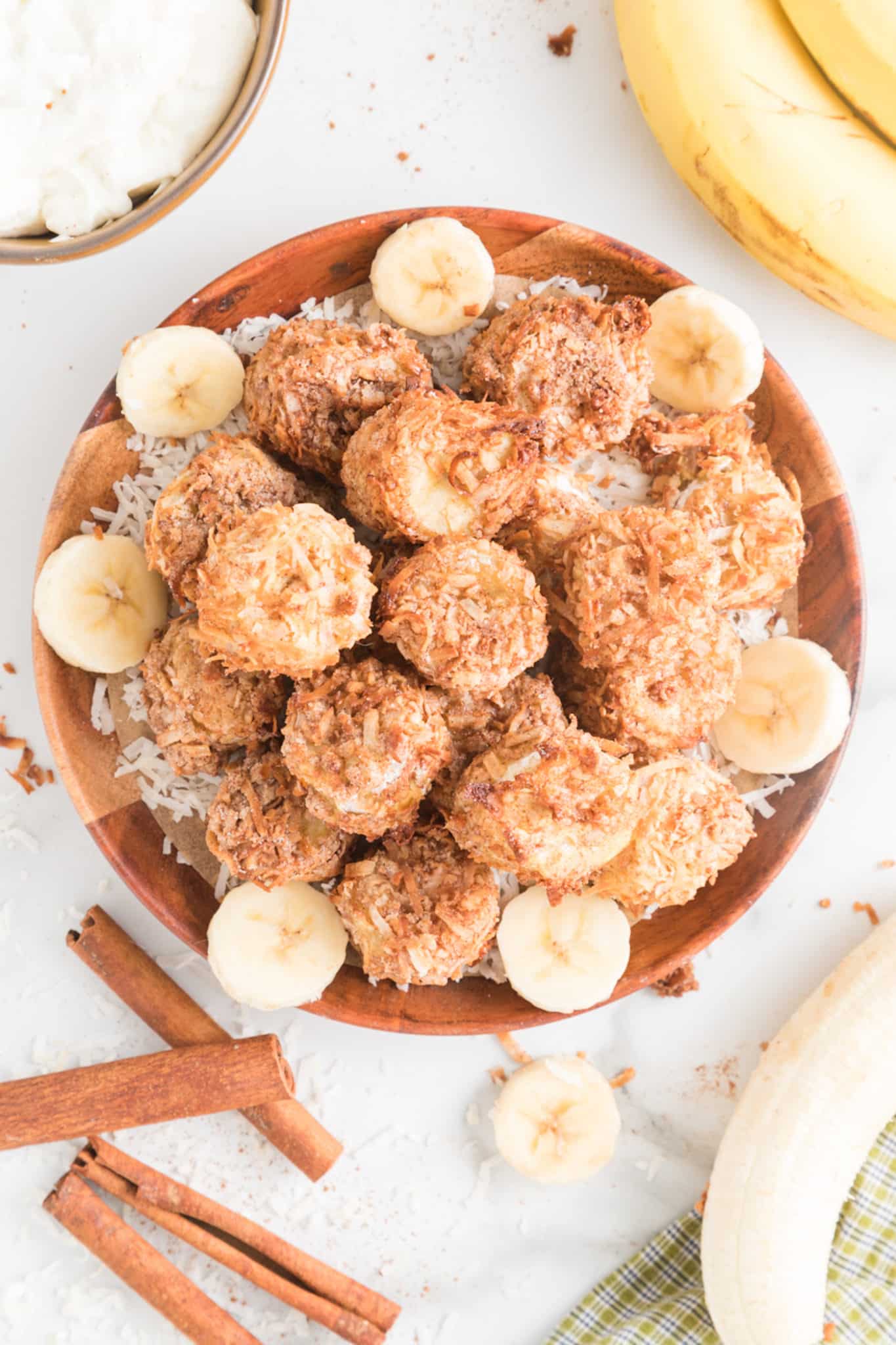 Air fried banana fritters served in a bowl with coconut.