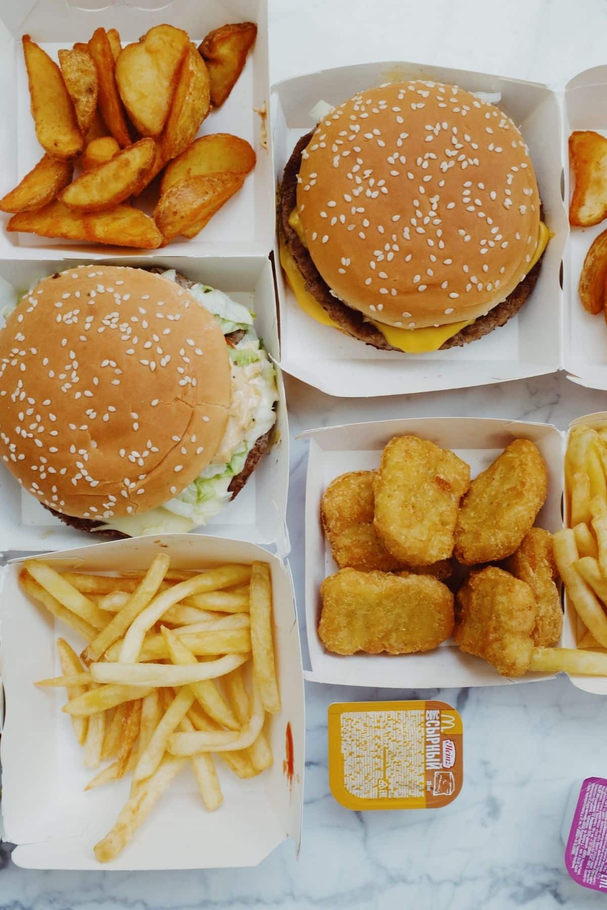 Hamburgers, Chicken nuggets, and Fries in paper bowls.