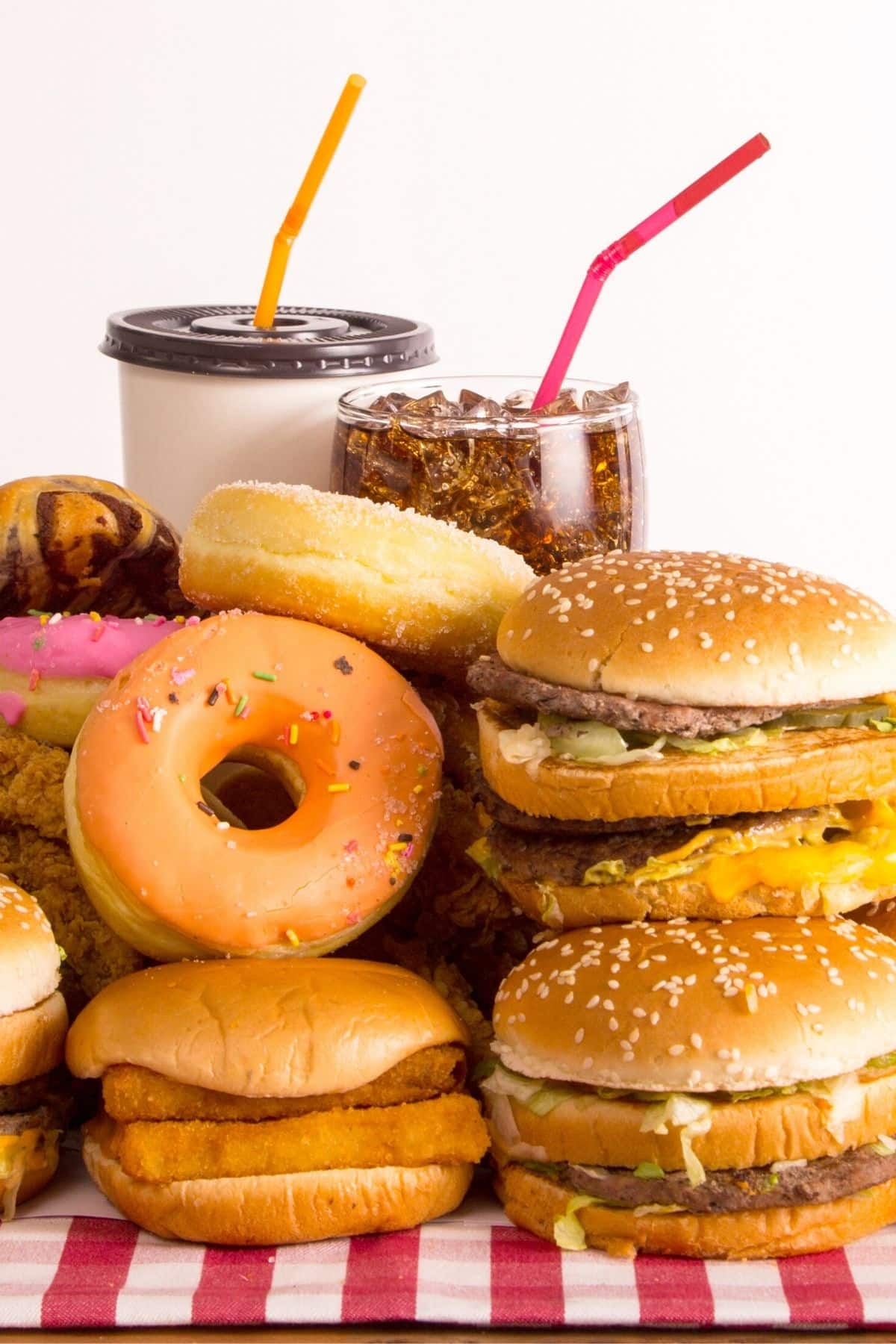 fast foods on a tabletop with checkered tablecloth.