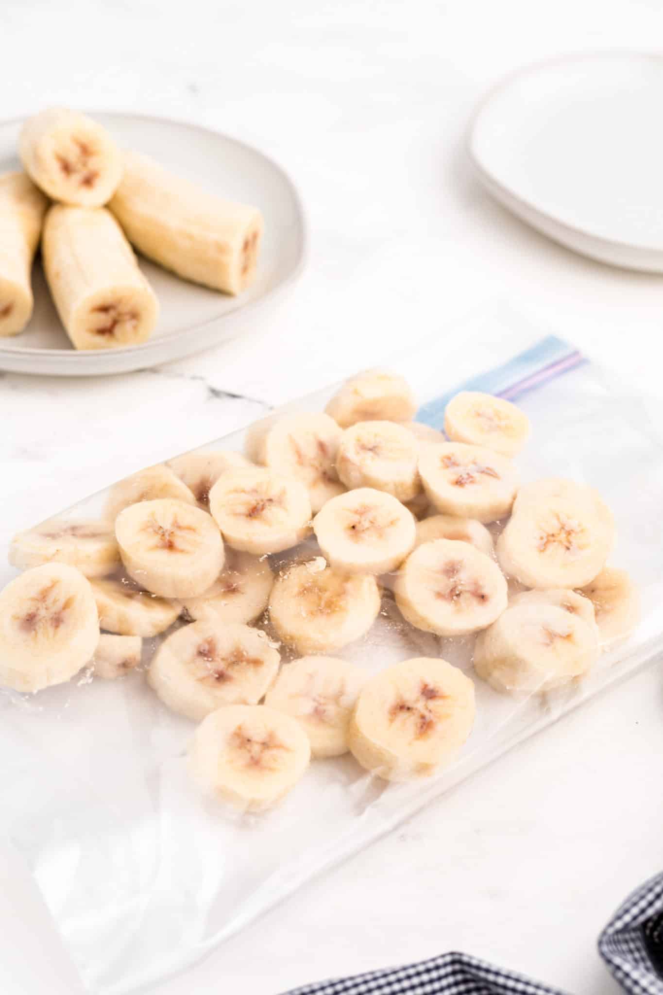Frozen banana slices in a zipper top bag on a white counter.