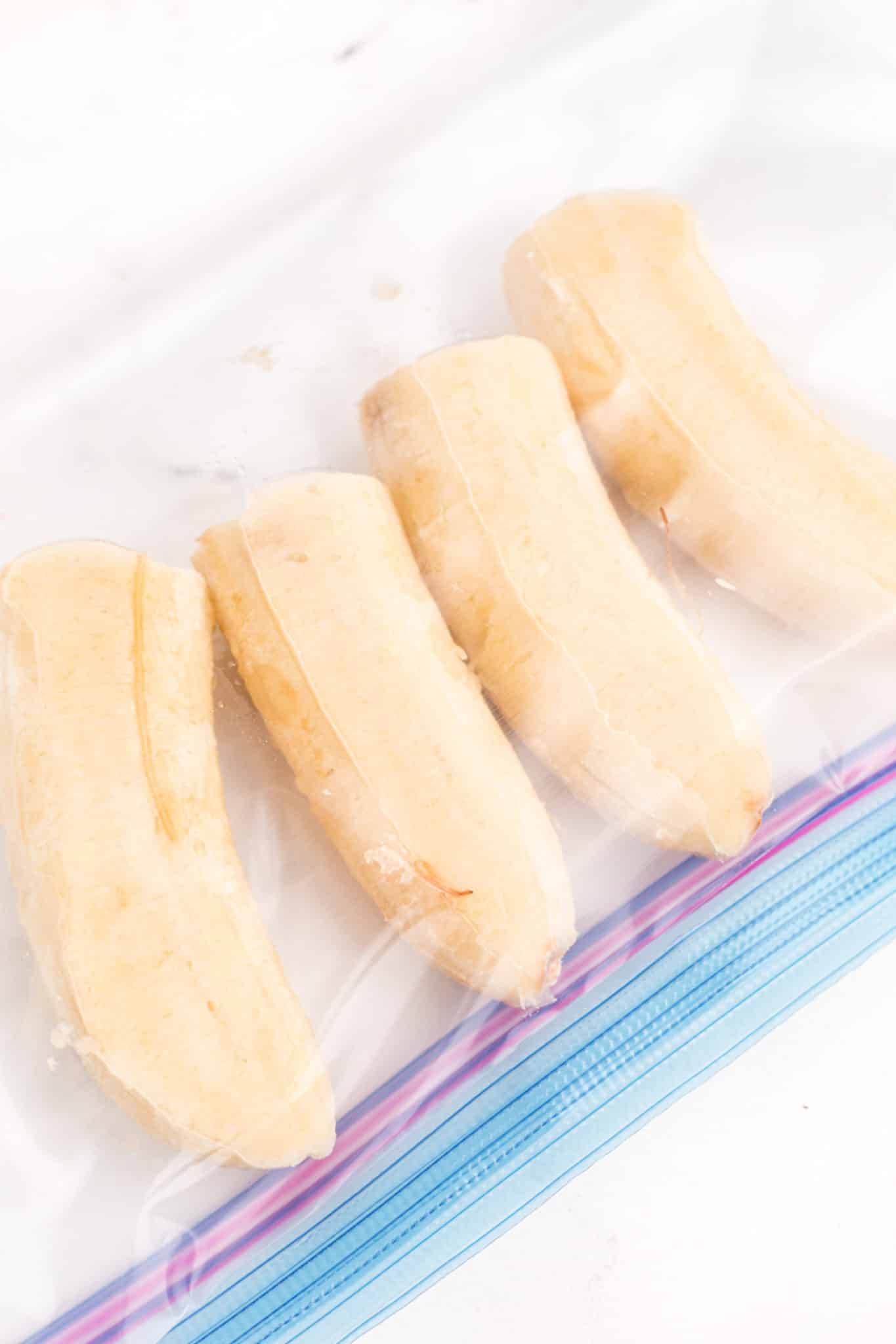 Four frozen banana halves in a zipper top bag.