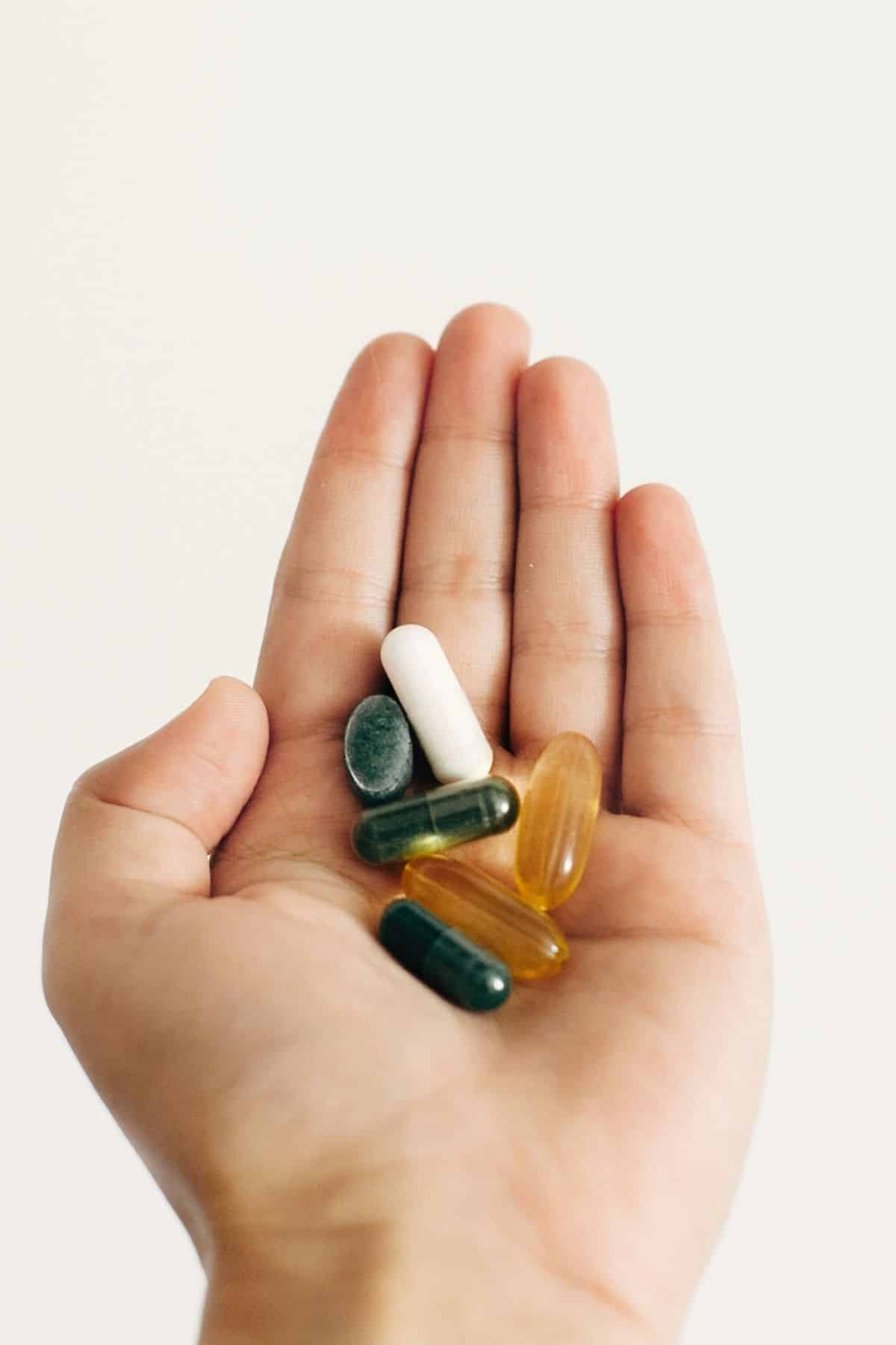 hand holding a variety of supplements.