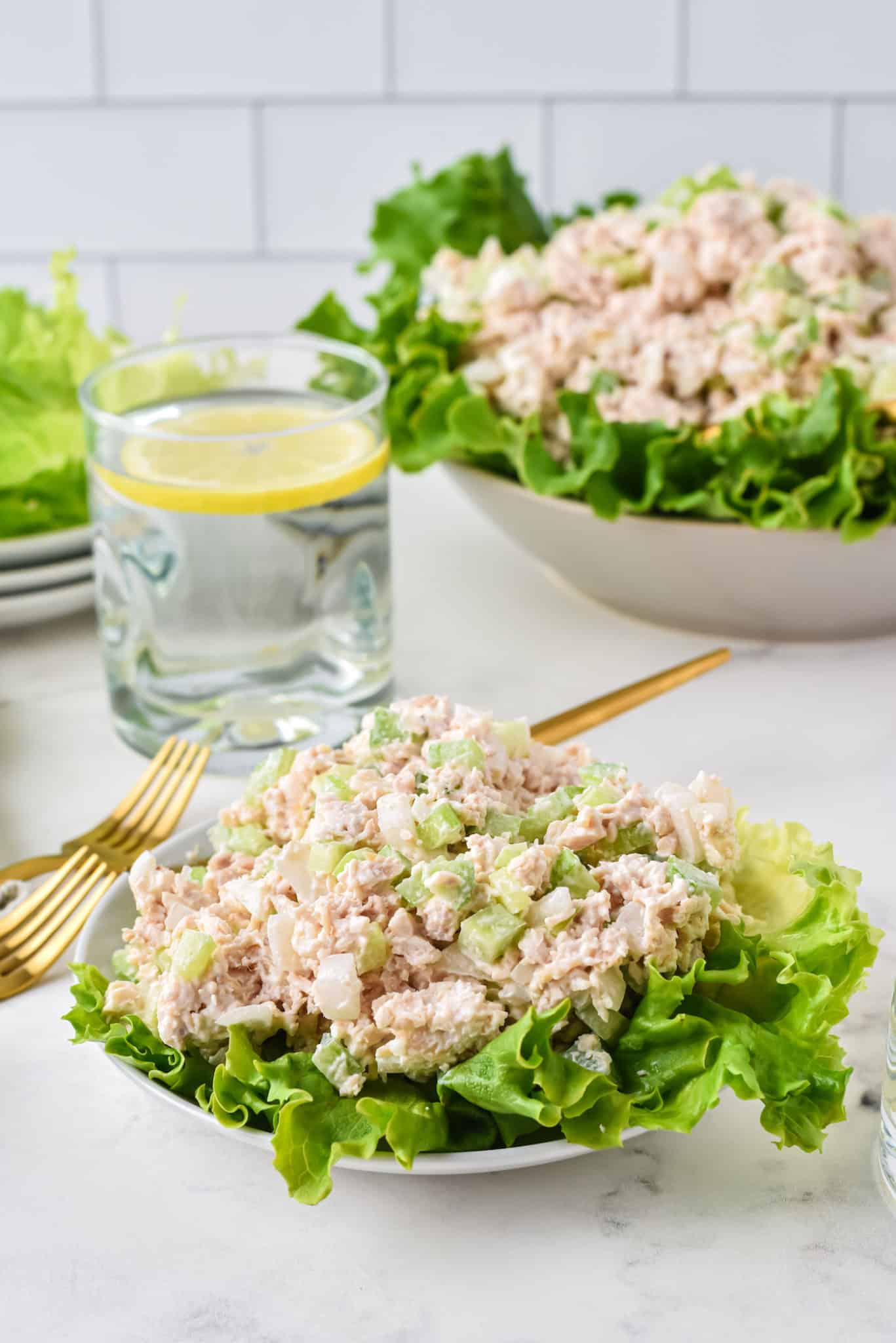 two bowls of costco chicken salad served with water and lemon.