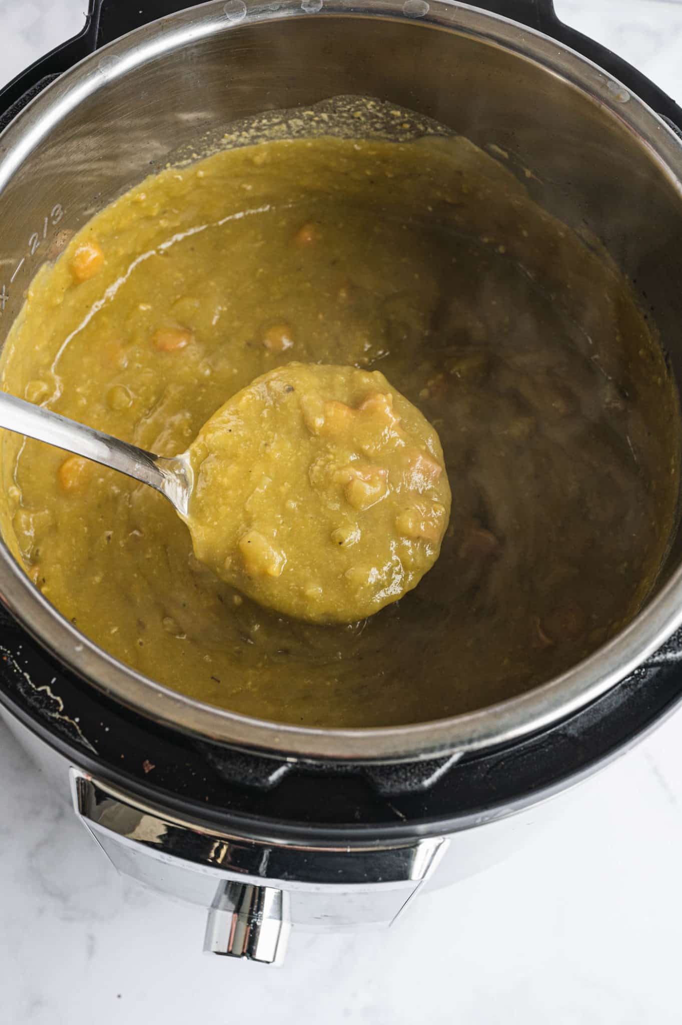 serving spoon with a serving of instant pot cooked split pea soup.