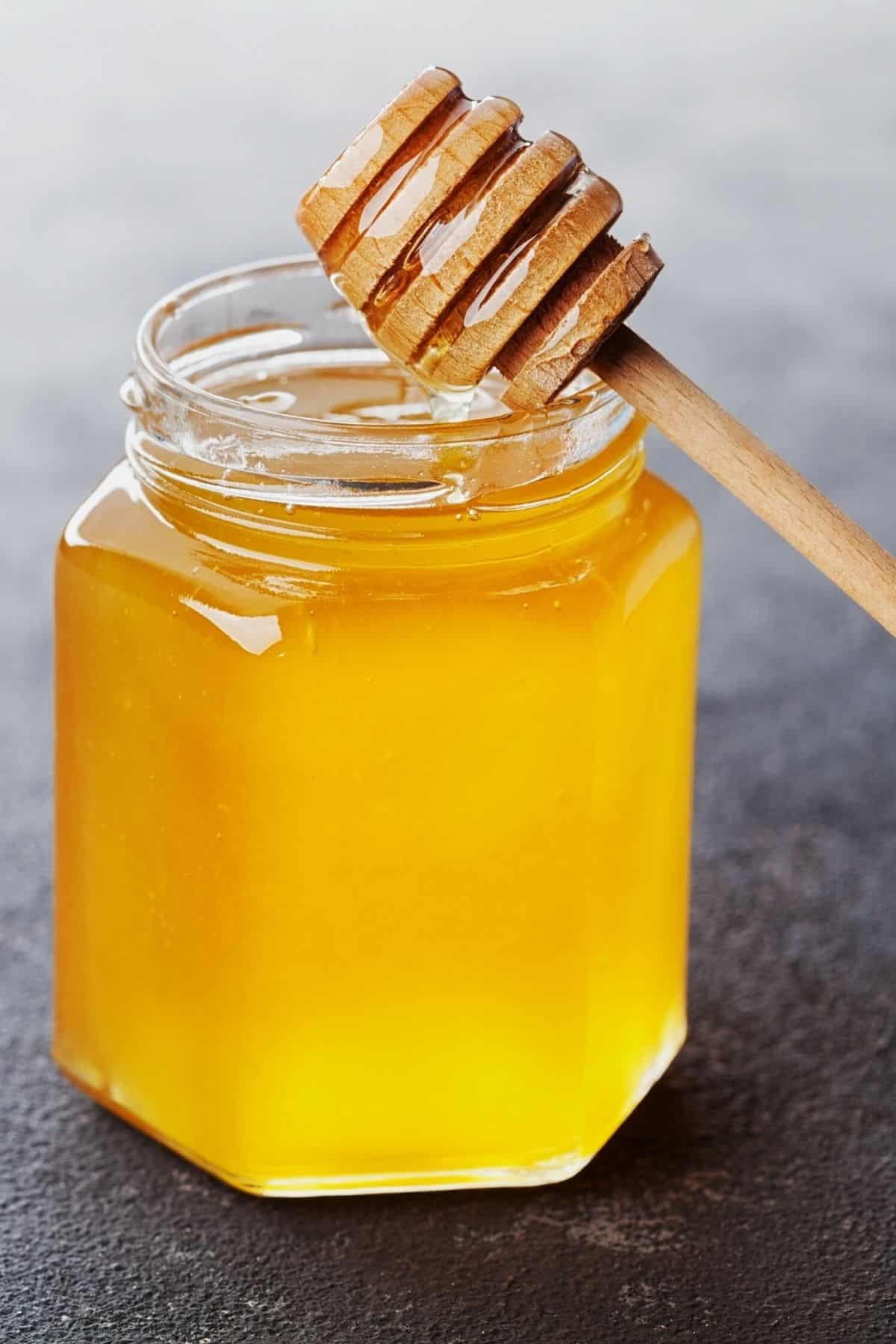 jar on honey on table.