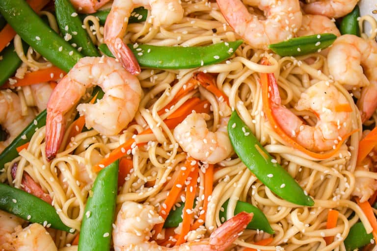 Close up of shrimp udon with peas and peppers in a bowl.