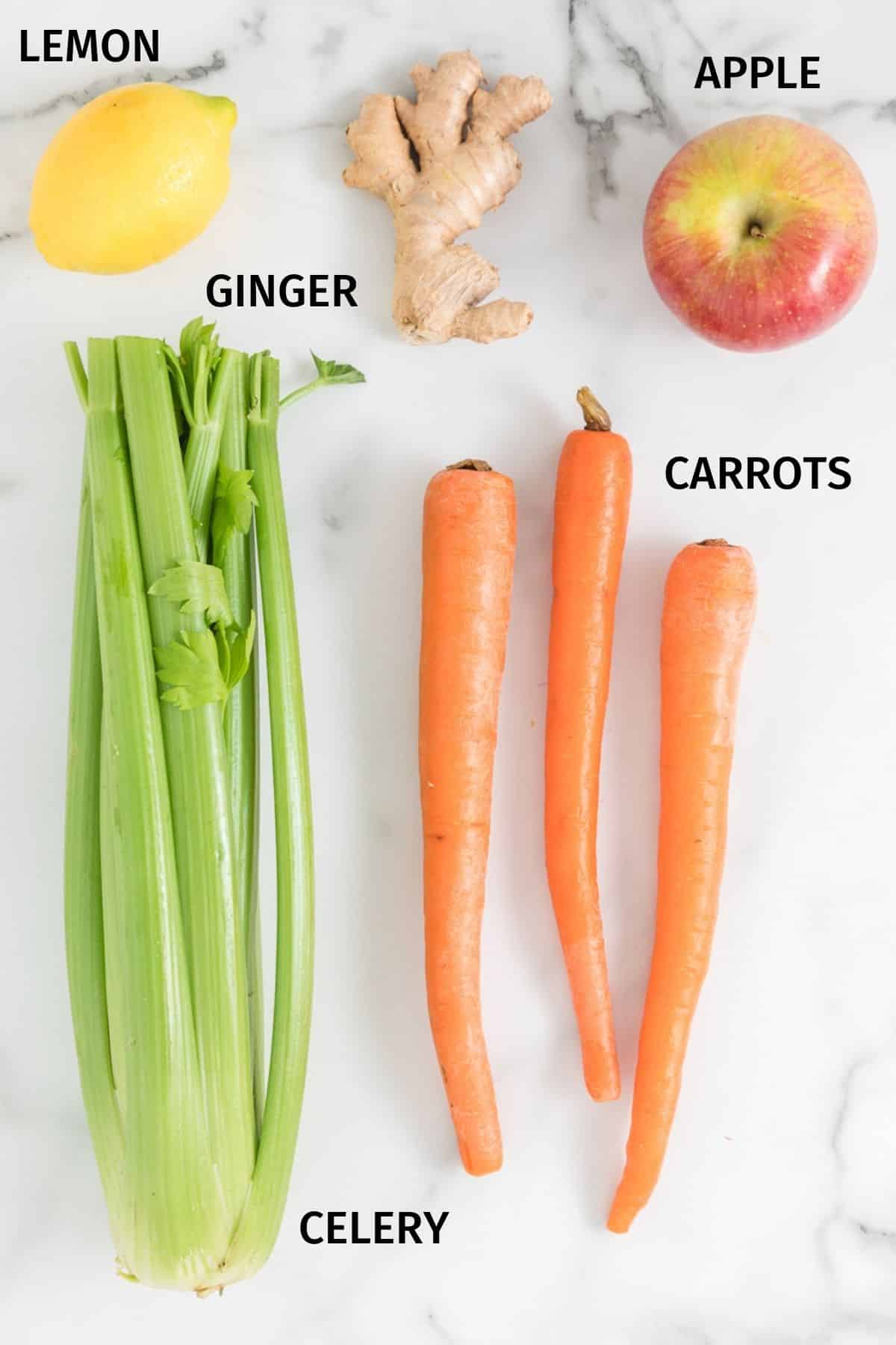 Ingredients for making carrot celery juice on a white surface.