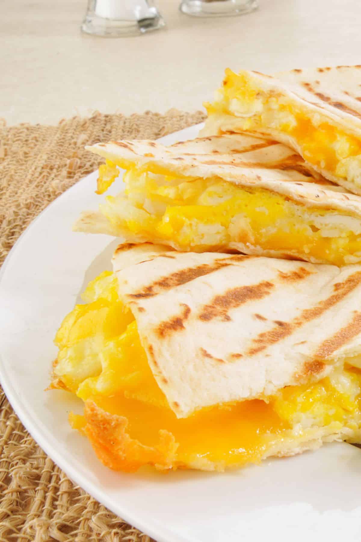 Egg and cheese breakfast quesadilla slices on a plate.