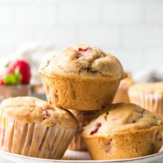 Strawberry muffins stacked up on a small white plate.