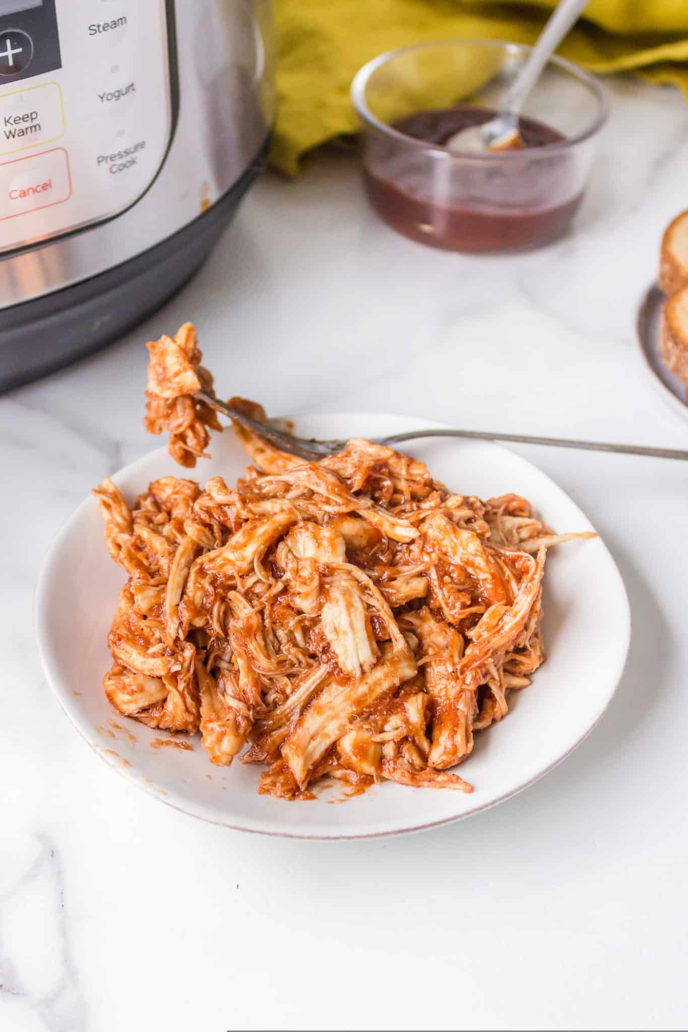 plate with cooked pulled instant pot bbq chicken.
