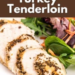 Sliced turkey tenderloin on a plate with green salad.
