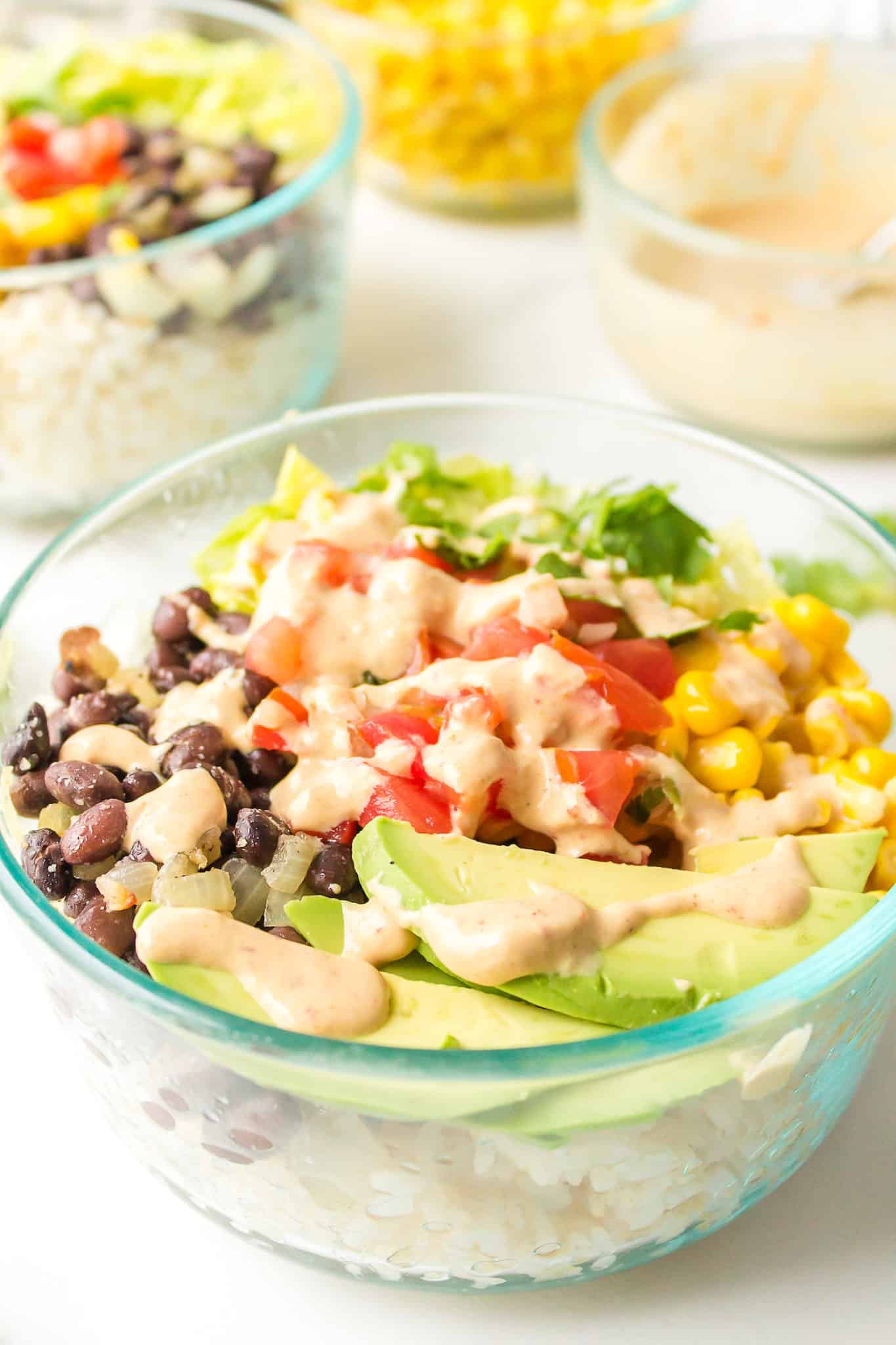 A clear glass bowl with a serving of Mexican brown rice Buddha bowl.