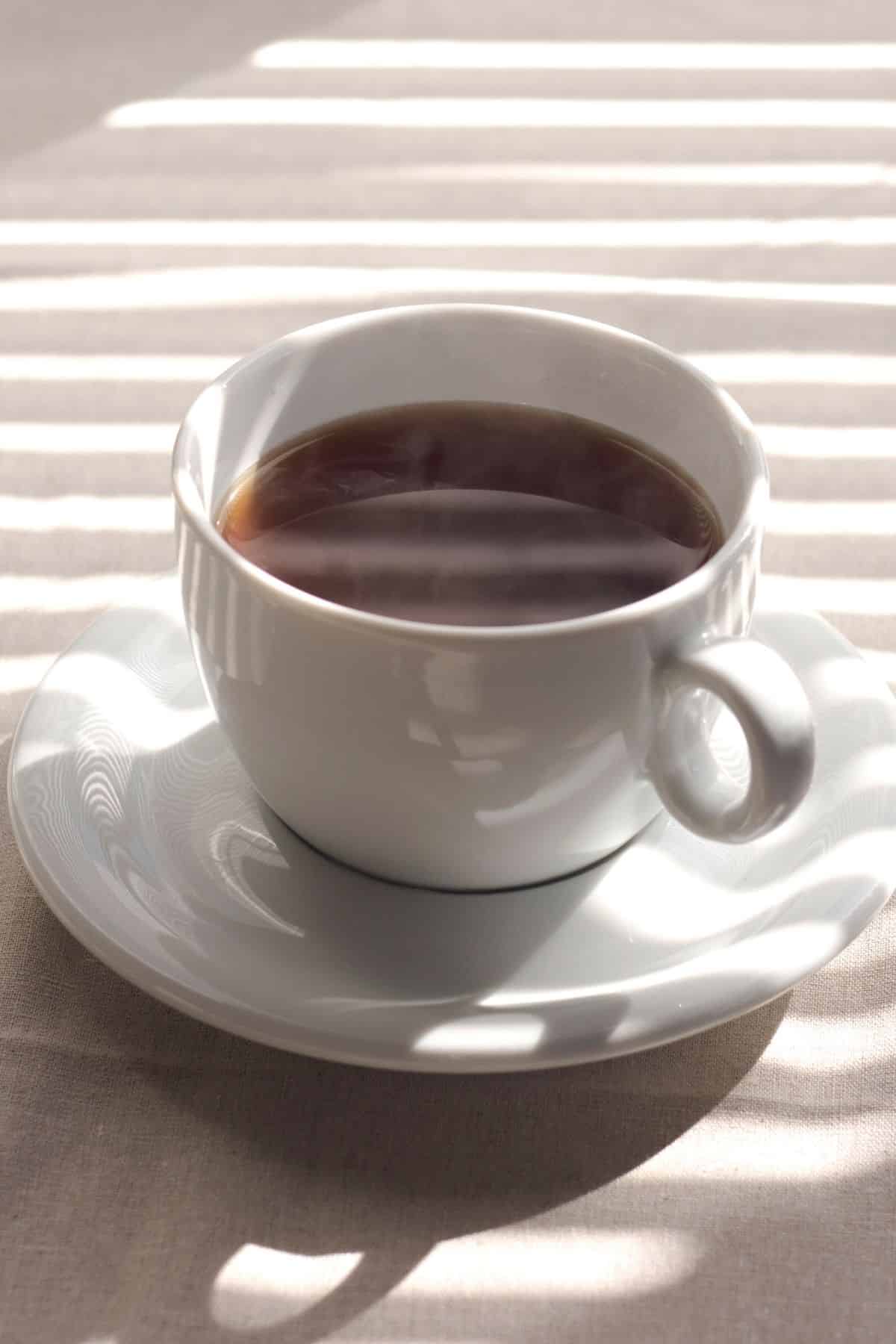 mug of steaming coffee on table.