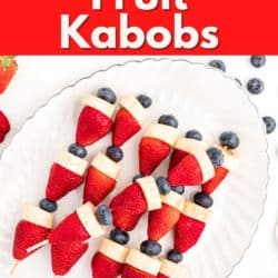 Red white and blue fruit kabobs on a white platter.